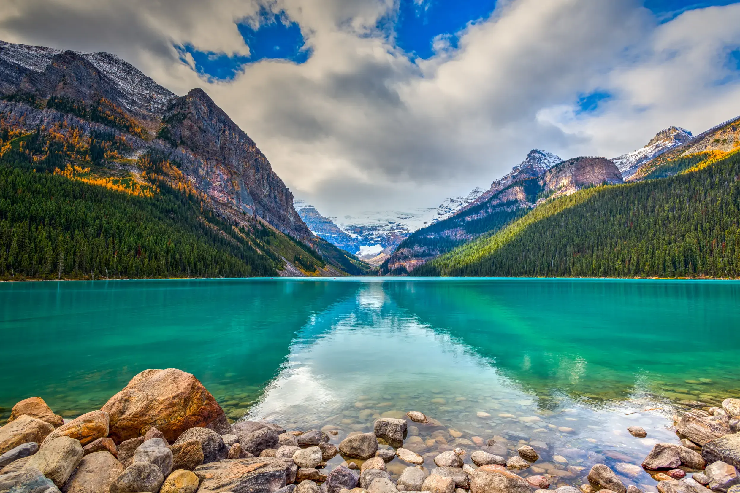 Smaragdgrüner Lake Louise im Banff-Nationalpark, in dessen ruhigem Wasser sich die kanadischen Rocky Mountains spiegeln.