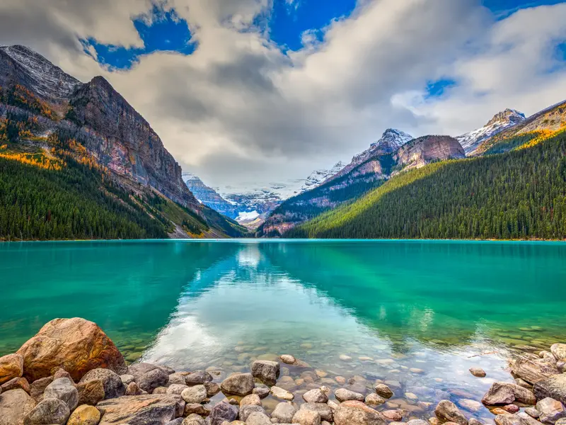 Smaragdgrüner Lake Louise im Banff-Nationalpark, in dessen ruhigem Wasser sich die kanadischen Rocky Mountains spiegeln.