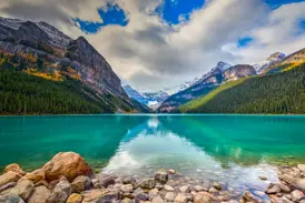 Smaragdgrüner Lake Louise im Banff-Nationalpark, in dessen ruhigem Wasser sich die kanadischen Rocky Mountains spiegeln.