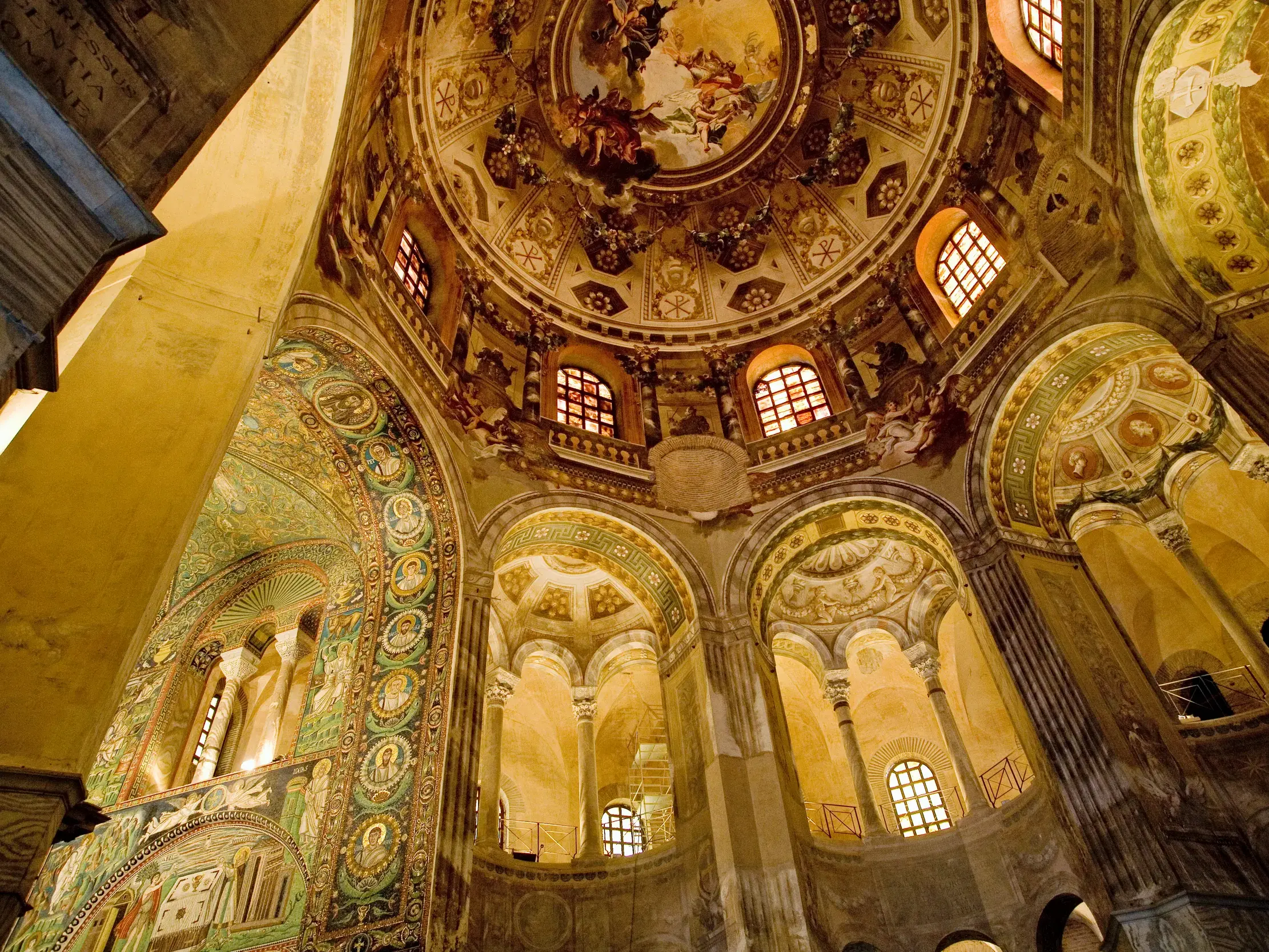 Blick nach oben zur goldfunkelnden Kuppel mit byzantinischen Mosaiken in der Basilika San Vitale in Ravenna.