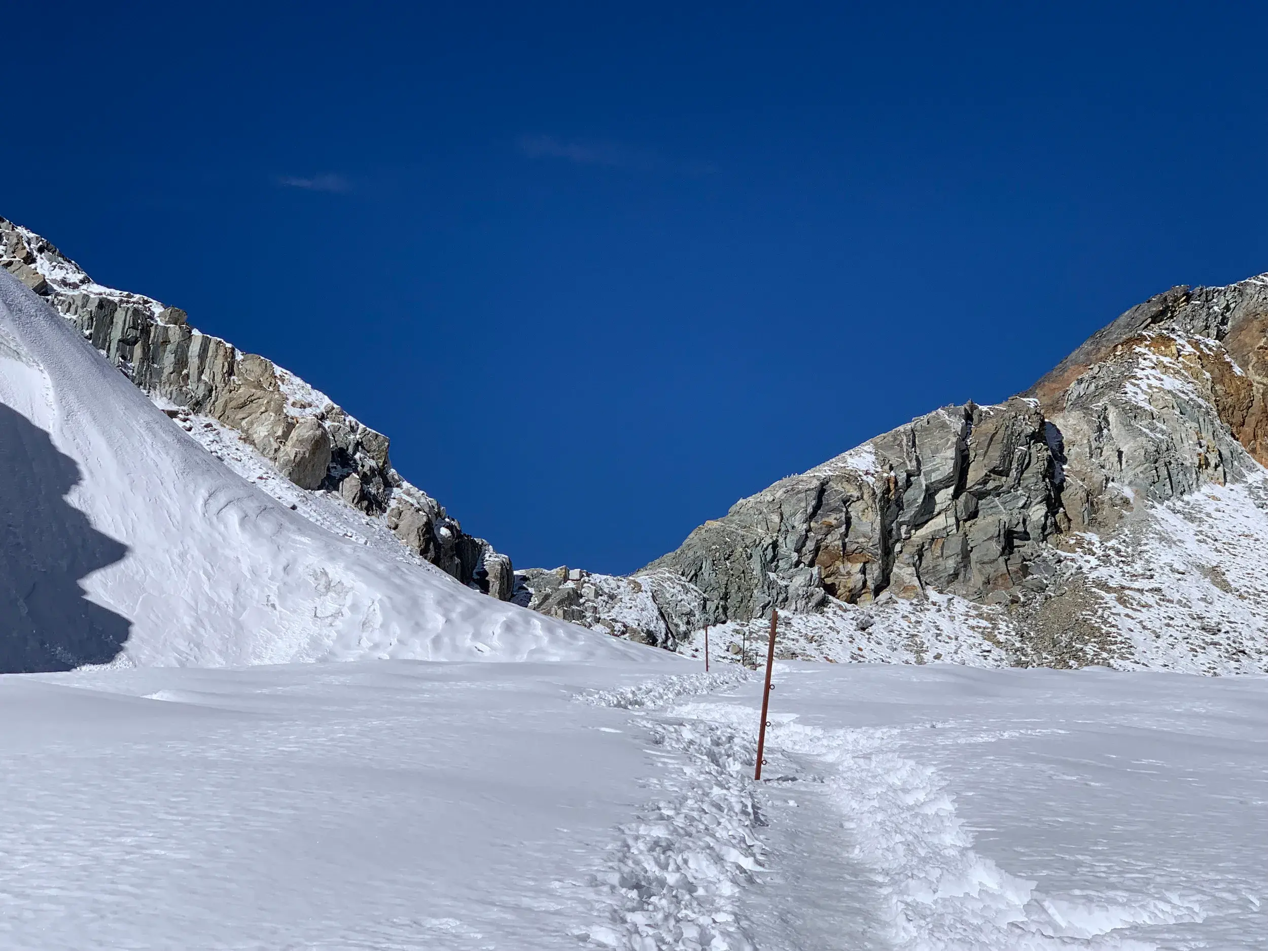 Schmaler Trekkingpfad im Schnee führt zwischen steilen Felshängen hinauf zu einem Hochpass wie dem Kongma La in Nepal.