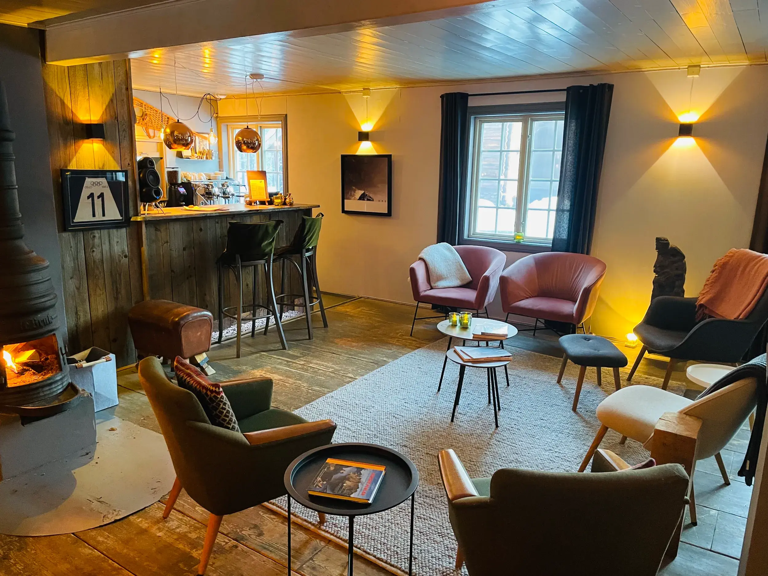 Gemütlicher Aufenthaltsraum der Harangtunet Mountain Lodge mit Kamin, Bar und einladenden Sesseln zum Entspannen.