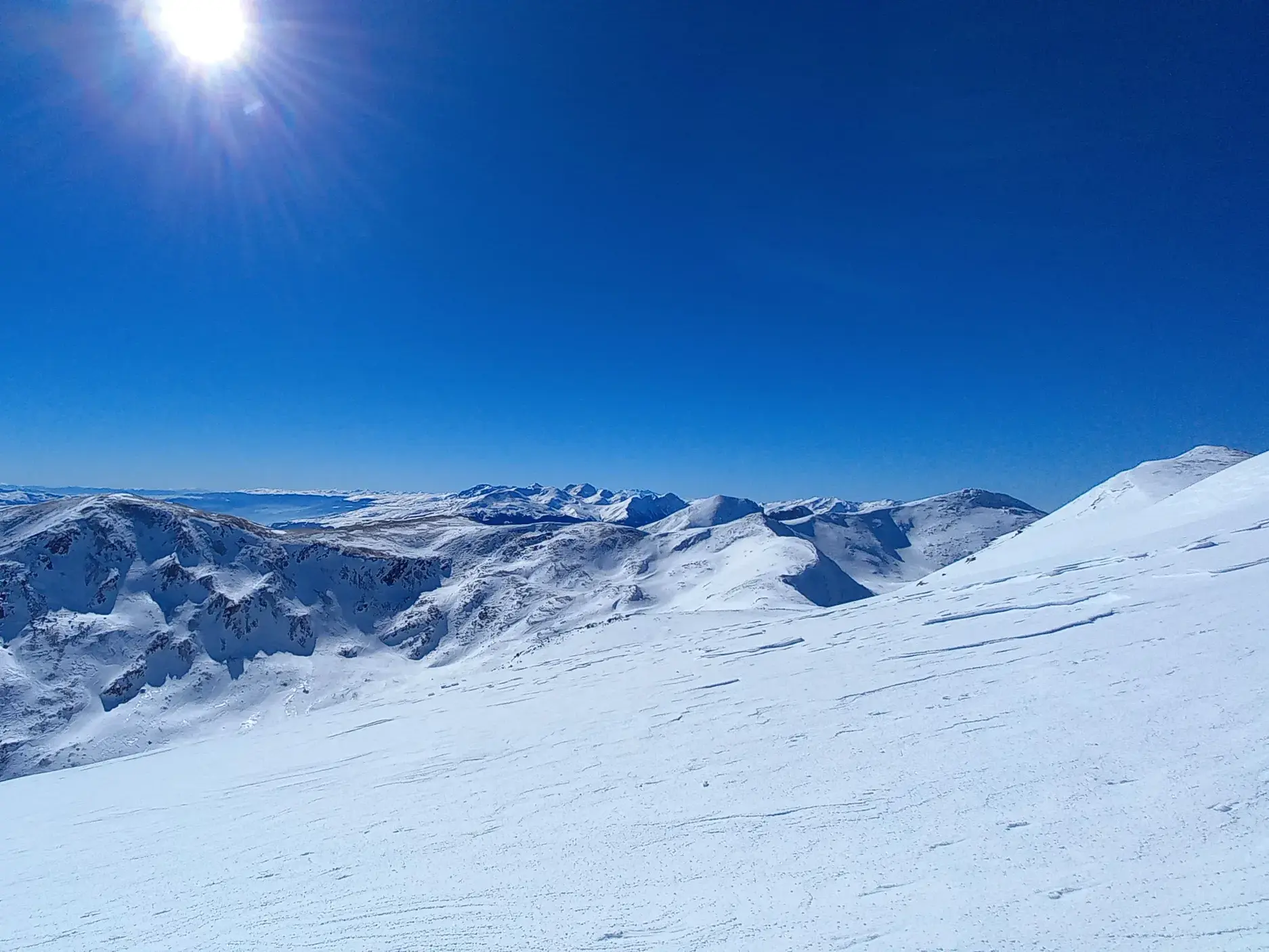 Blick auf tief verschneite Gipfel im Sharr-Gebirge im Kosovo während einer sonnigen Skitour in unberührter Natur.