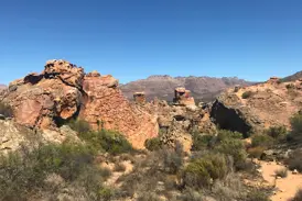 Zerklüftete, rote Sandsteinformationen in der kargen Gebirgslandschaft der südafrikanischen Cederberge bei einer Wanderung.