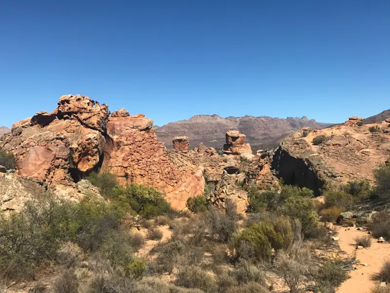 Markante rote Sandsteinformationen in der trockenen Wanderlandschaft der südafrikanischen Cederberge bei Kapstadt.
