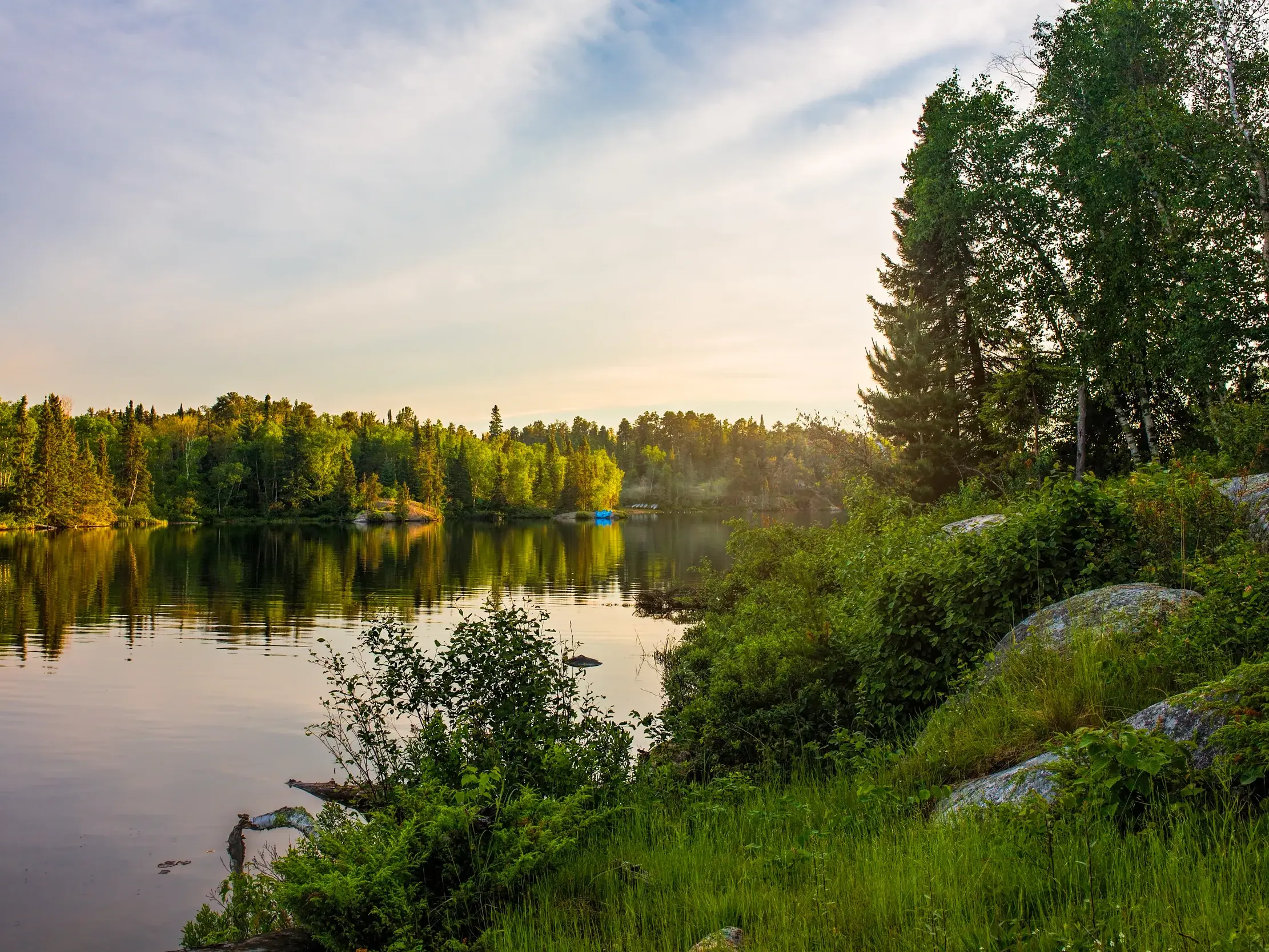 Abendstimmung auf einer Radreise in der Thousand-Islands-Region in Kanada, wo sich dichte Wälder im stillen See spiegeln.