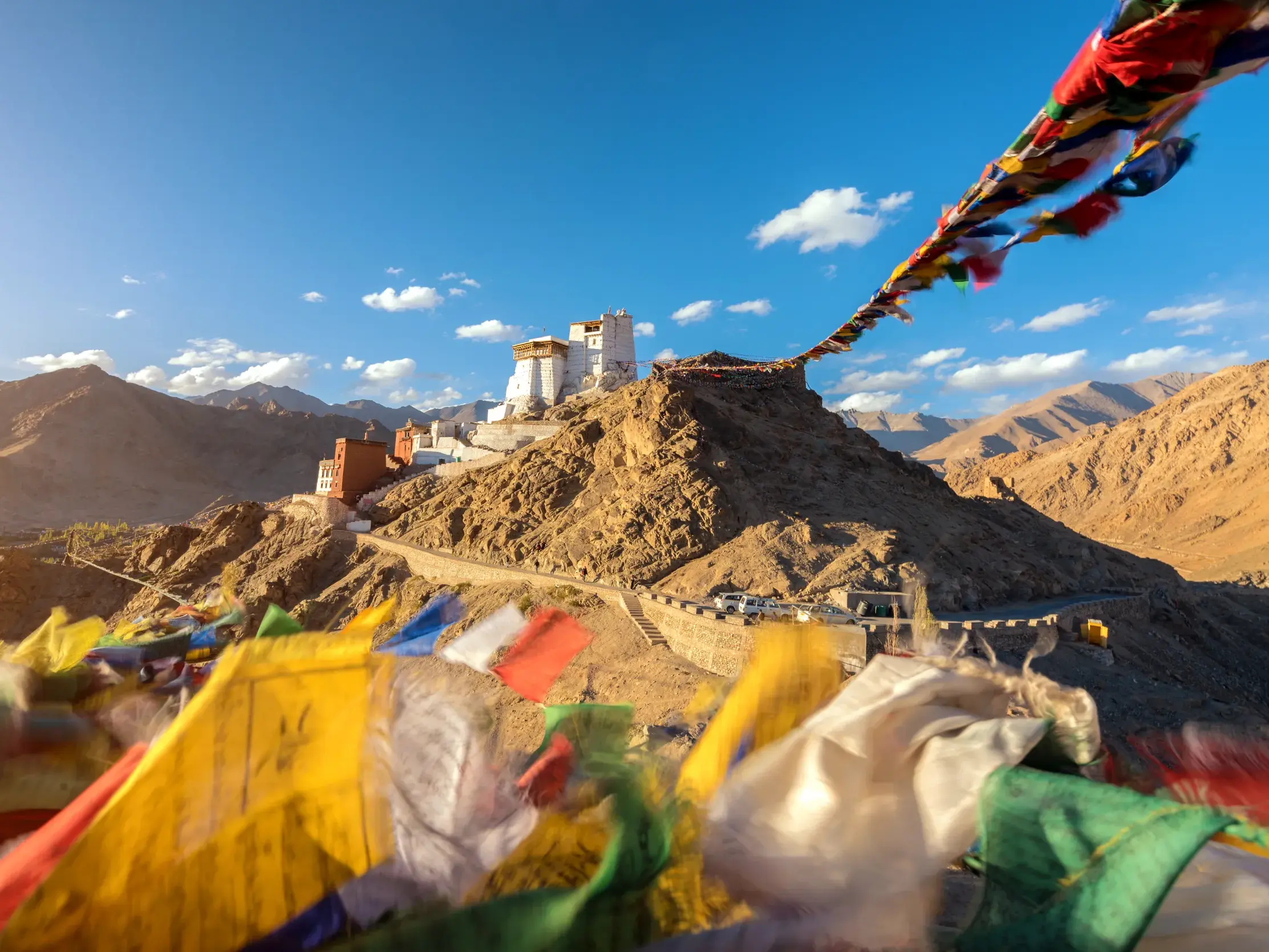 Bunte Gebetsfahnen wehen im Wind vor dem majestätischen Tikse Kloster, das auf einem Hügel in Ladakh thront.