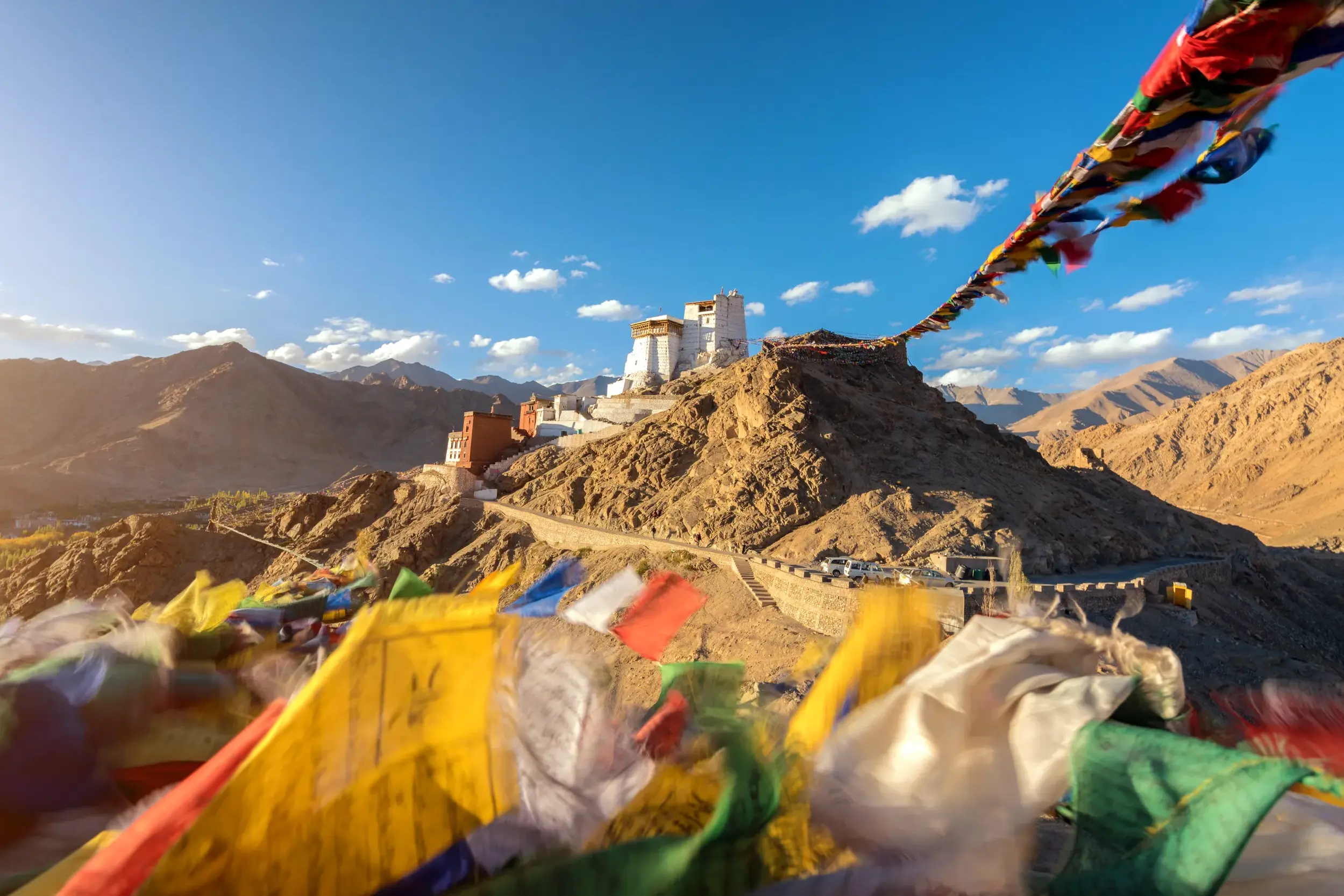 Bunte Gebetsfahnen wehen im Wind vor dem majestätischen Tikse Kloster, das auf einem Hügel in Ladakh thront.