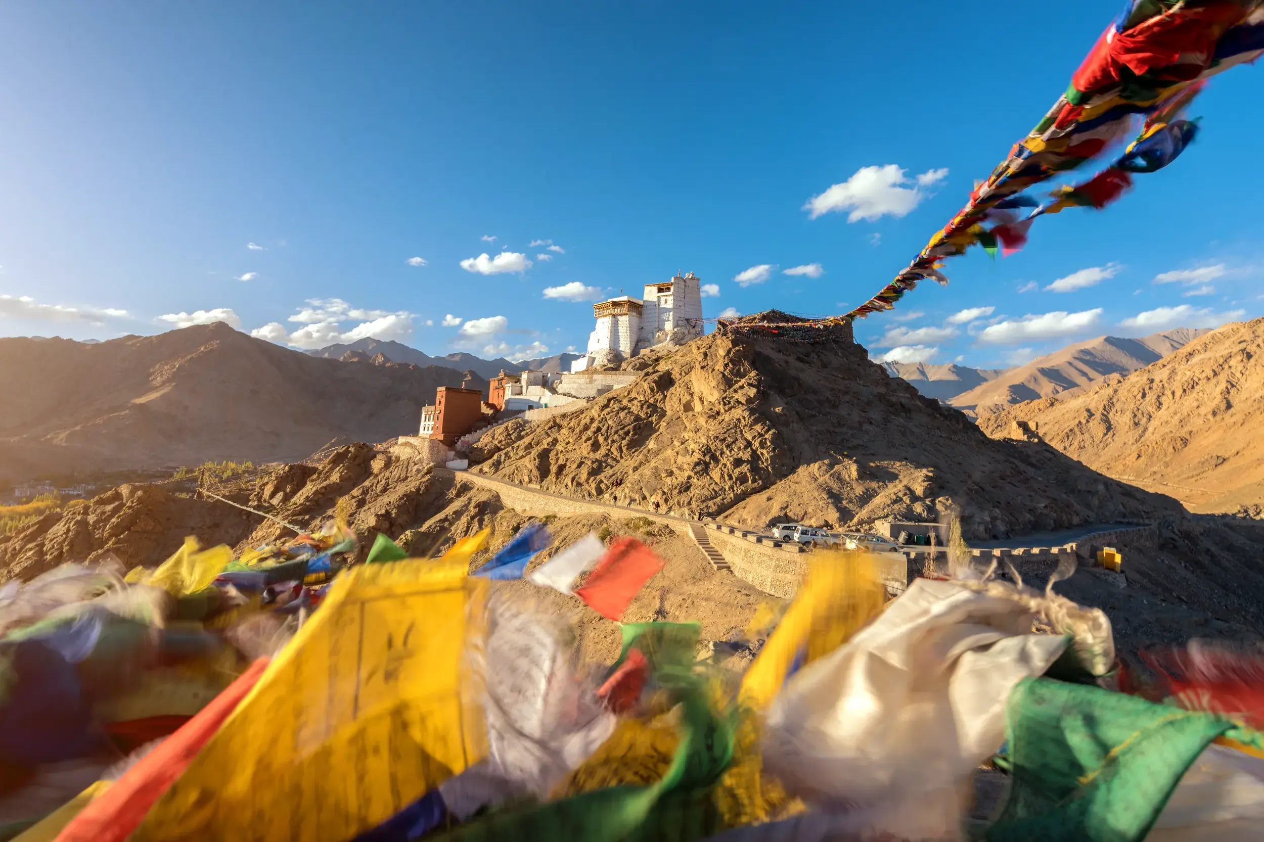 Bunte Gebetsfahnen wehen im Wind vor dem majestätischen Tikse Kloster, das auf einem Hügel in Ladakh thront.