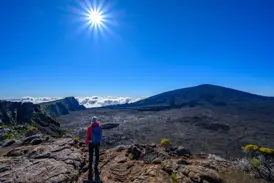 Wanderer bei einer Trekking-Tour auf La Réunion blickt auf die riesige Caldera des aktiven Vulkans Piton de la Fournaise.