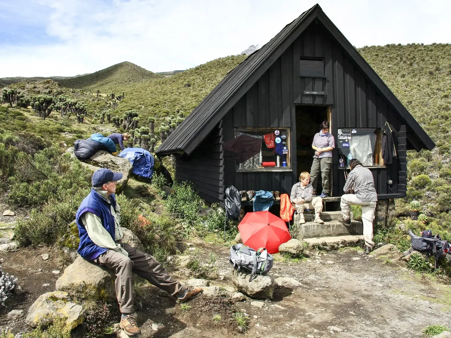 Wanderer bei einer Rast zur Akklimatisation an der Horombo-Hütte auf der Marangu-Route am Kilimanjaro.