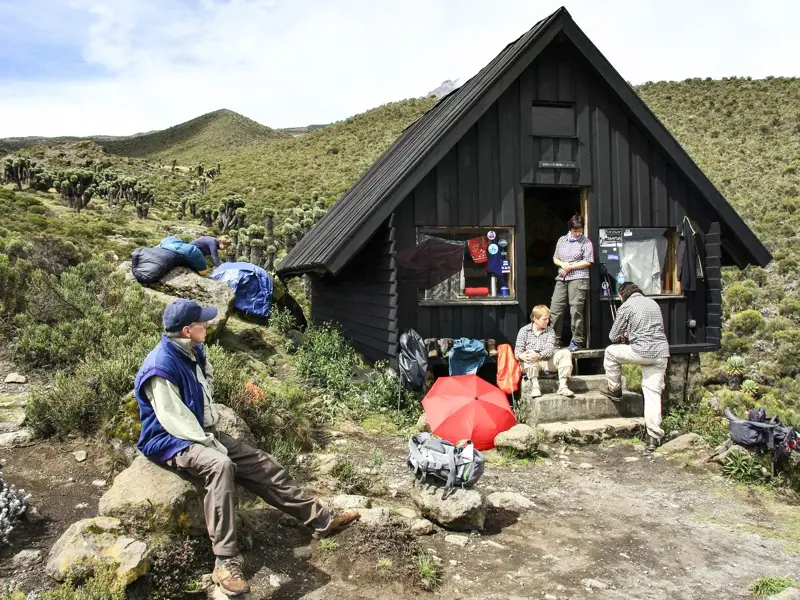 Wanderer bei einer Rast zur Akklimatisation an der Horombo-Hütte auf der Marangu-Route am Kilimanjaro.