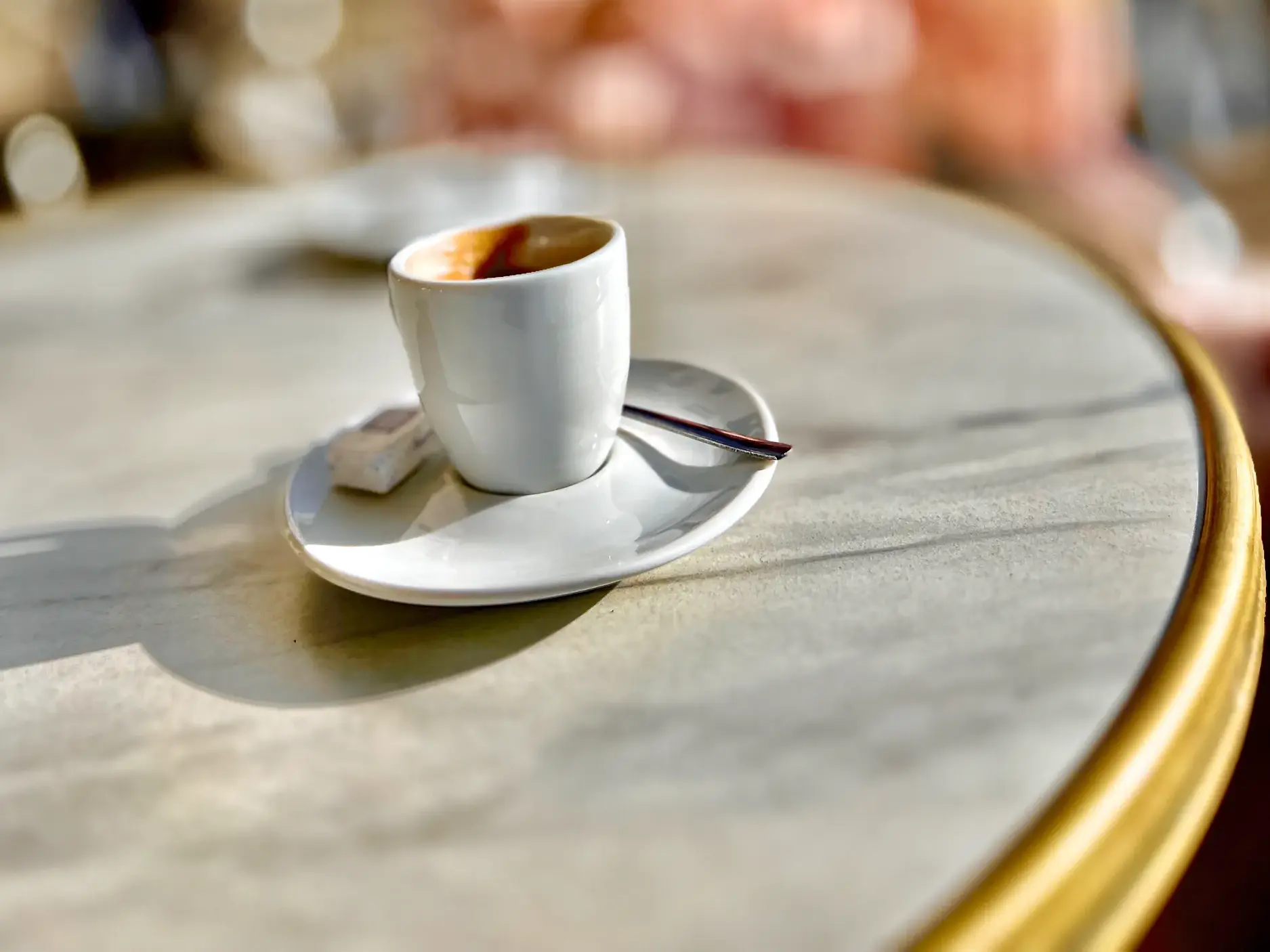 Kaffeepause während einer Studienreise nach Frankreich: Eine weiße Espressotasse steht auf einem Marmortisch.