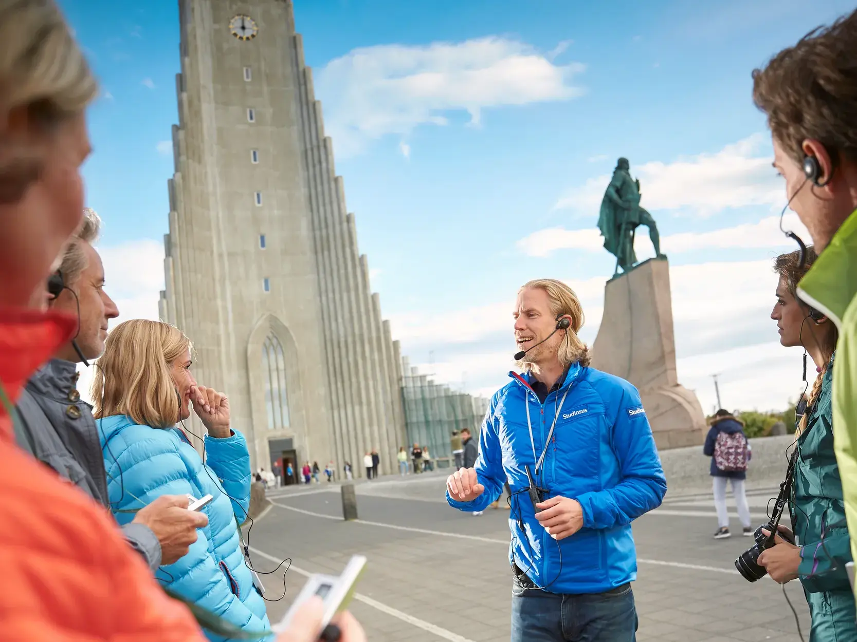 Studiosus Reiseleiterin erklärt einer Reisegruppe die Sehenswürdigkeiten beim Stadtrundgang in Reykjavik.