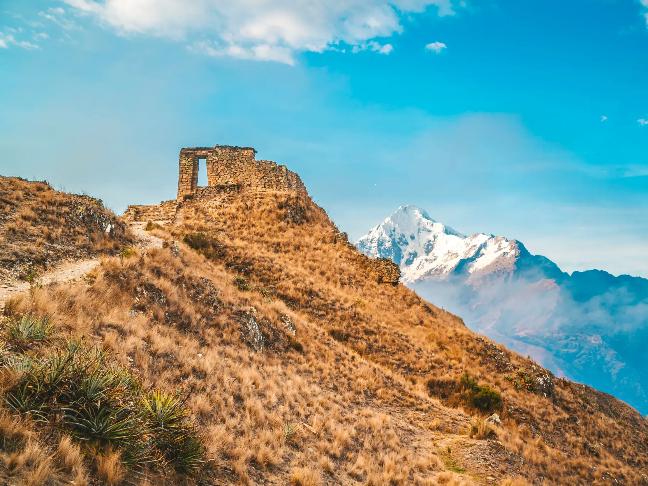 Wanderweg zum Sonnentor Inti Punku auf dem Inkatrail mit Blick auf einen schneebedeckten Gipfel der Anden in Peru.