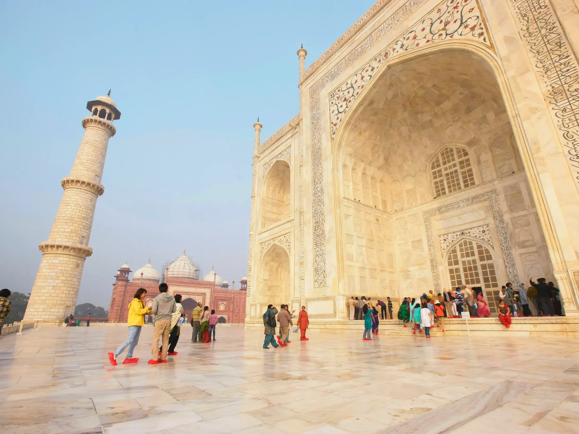 Eine Reisegruppe erkundet auf einer Studienreise das berühmte Taj Mahal, ein Mausoleum aus weißem Marmor in Agra.