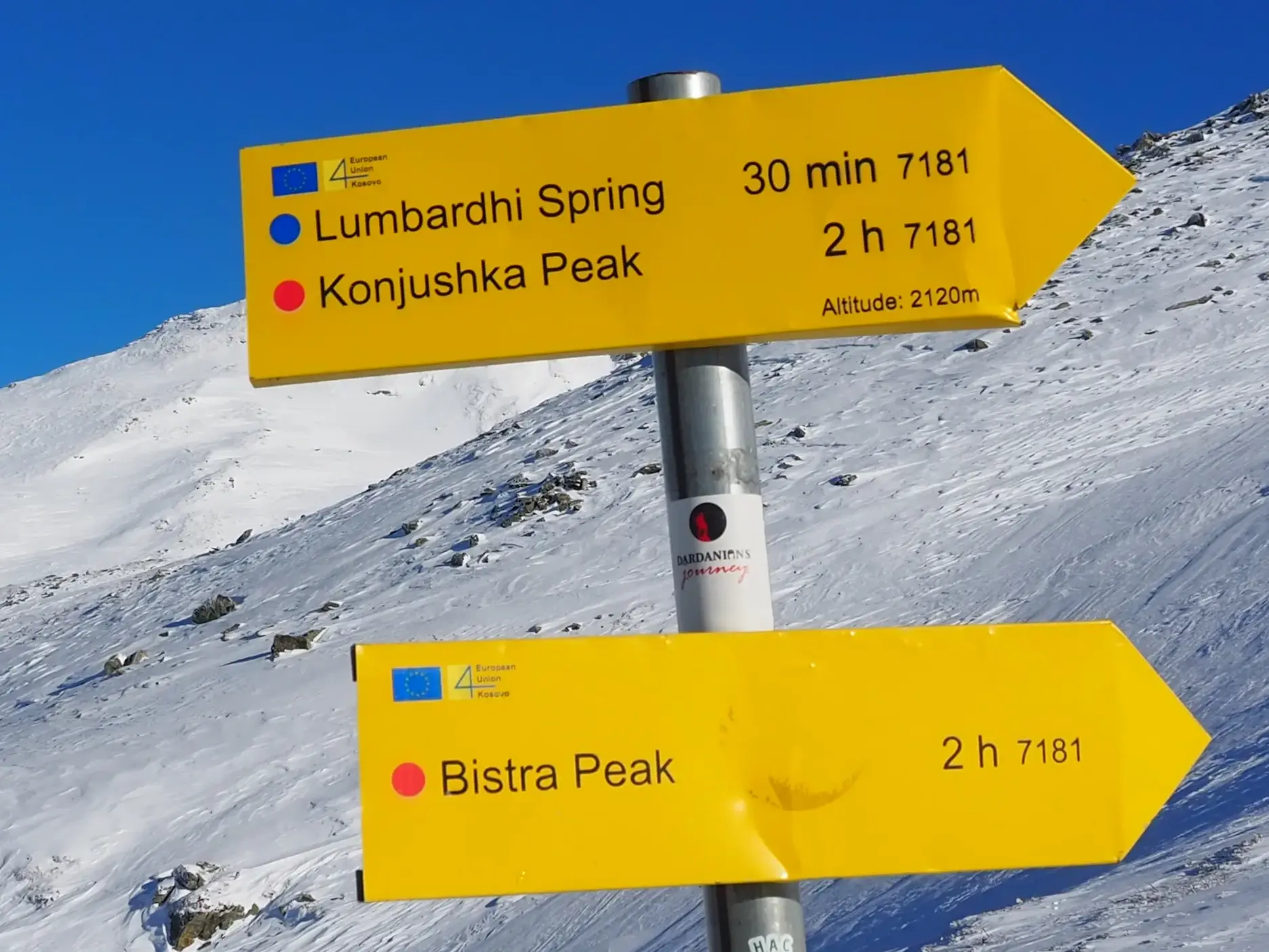 Gelbe Wegweiser auf einer Skitour im Sharr-Gebirge im Kosovo, die den Weg zu den Gipfeln Konjushka Peak und Bistra Peak weisen.