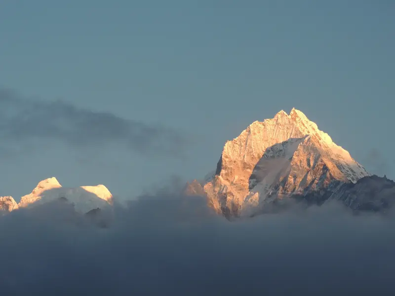 Atemberaubender Blick auf den Gipfel der Ama Dablam, beleuchtet von der Morgensonne über den Wolken der Khumbu-Region.