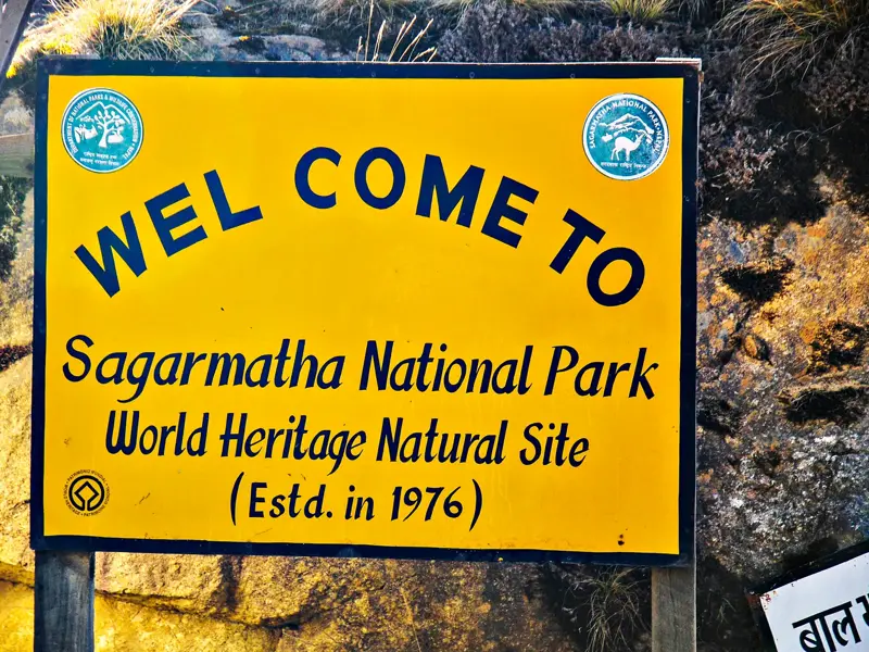 Gelbes Willkommensschild am Eingang zum Sagarmatha-Nationalpark in Nepal, dem UNESCO-Weltnaturerbe der Everest-Region.