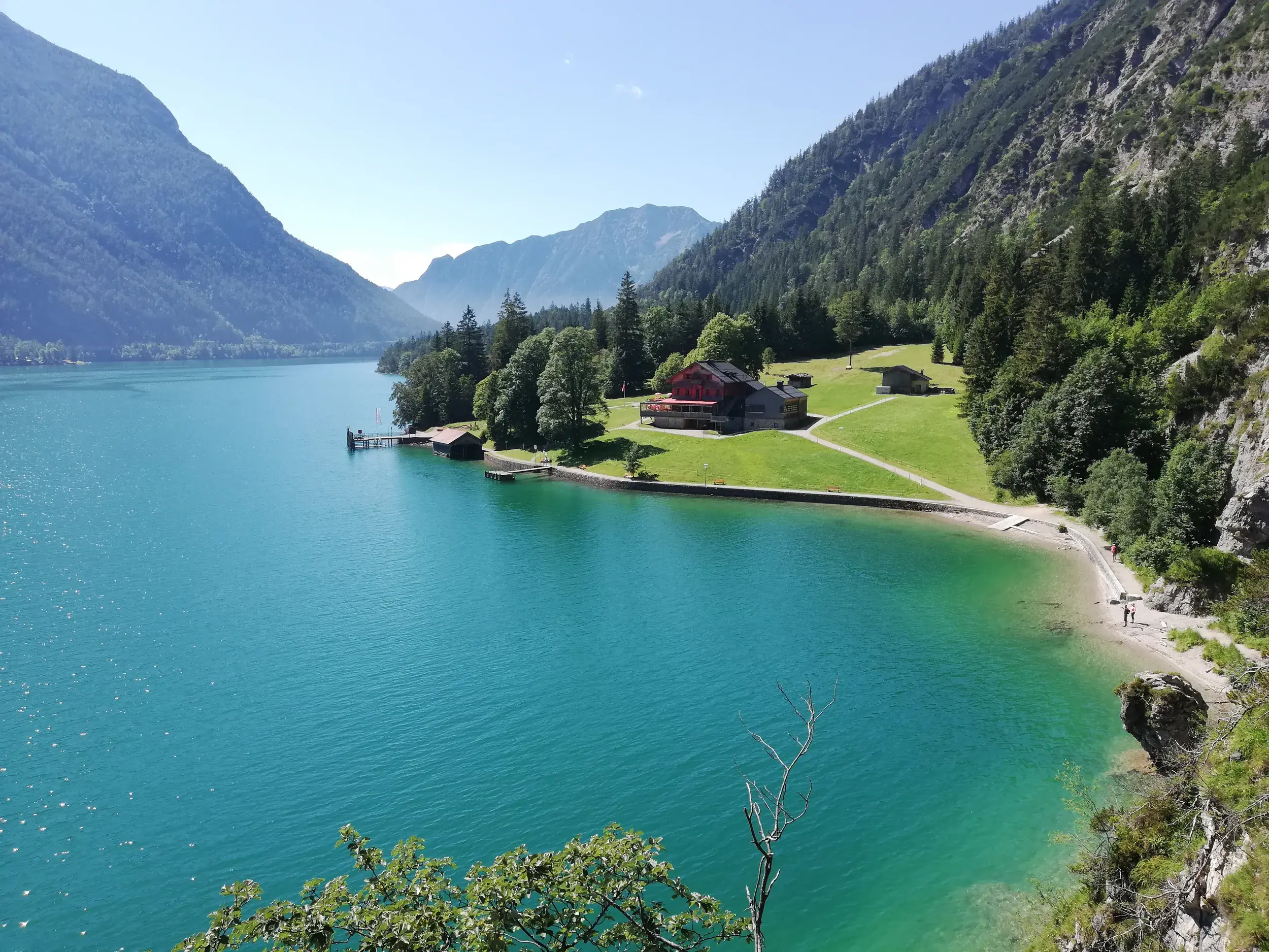 Blick vom Gaisalmsteig auf den türkisfarbenen Achensee und die Gaisalm, umgeben von den Bergen des Naturpark Karwendel.