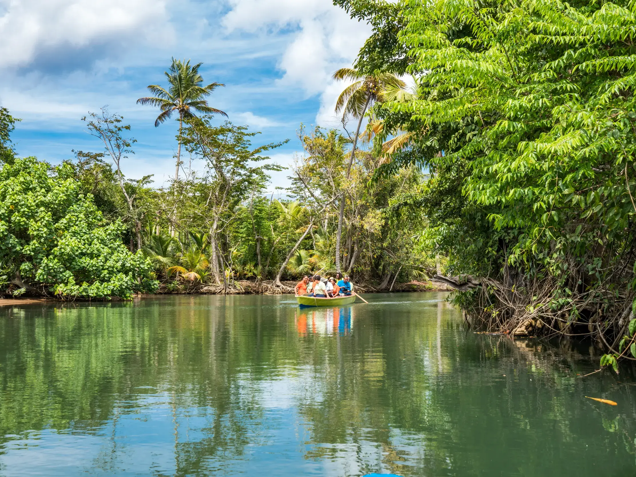 Eine kleine Reisegruppe erkundet im Boot die üppige Mangrovenwildnis des Indian River auf der Karibikinsel Dominica.