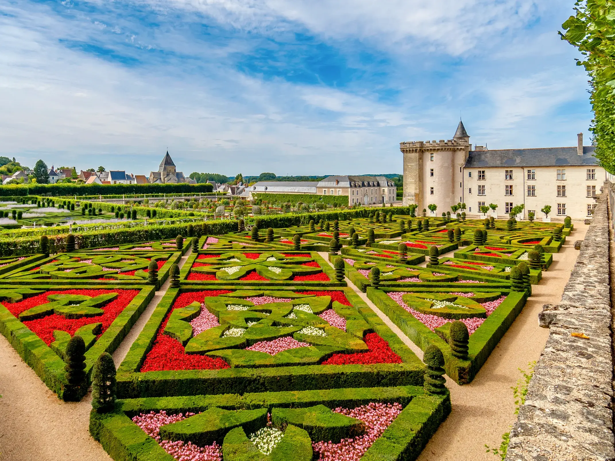 Prachtvoller Renaissancegarten von Schloss Villandry mit kunstvollen Ornamenten aus Buchsbaumhecken und roten Blumenbeeten.