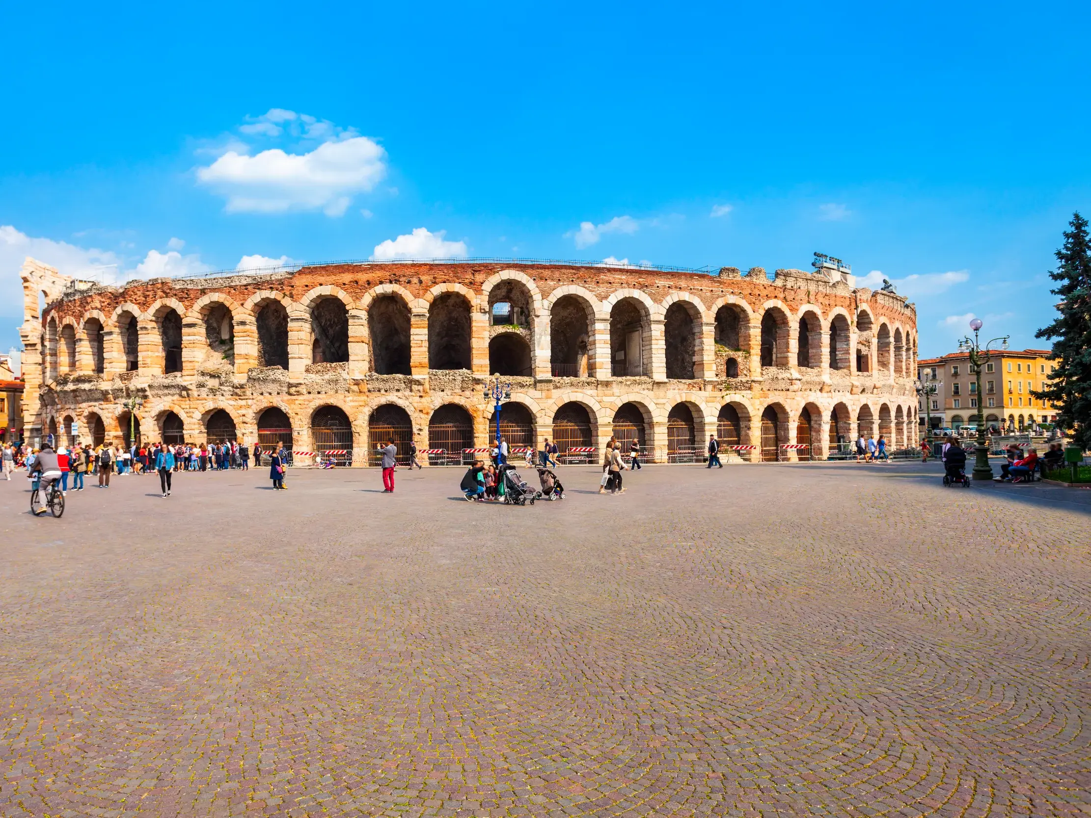 Die beeindruckende Arena in Verona auf einer Studiosus Studienreise durch Venetien, mit Reisenden auf dem weiten Vorplatz.