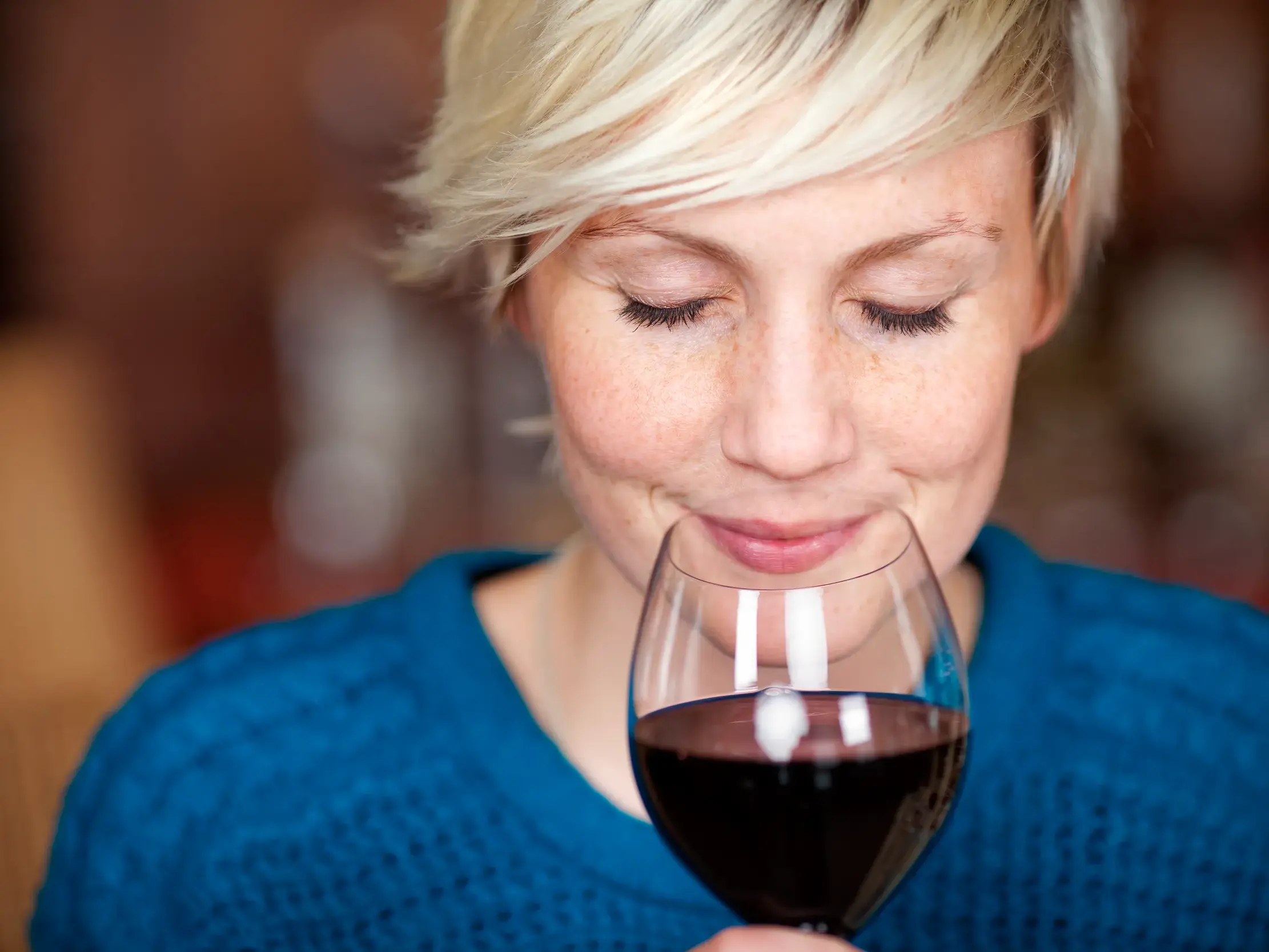 Eine Frau riecht genussvoll an einem Glas kanarischen Weins während des Mojo-Workshops in Icod de los Vinos auf Teneriffa.