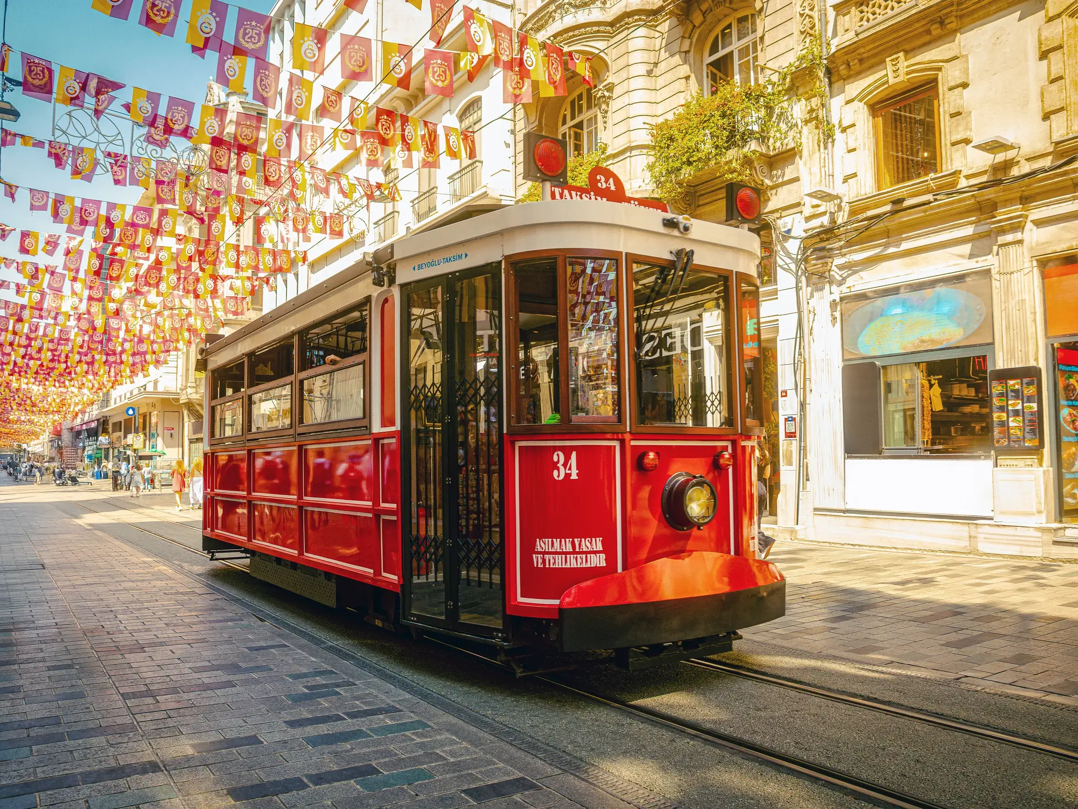 Ikonische rote Straßenbahn auf der belebten İstiklalstraße in Istanbul.