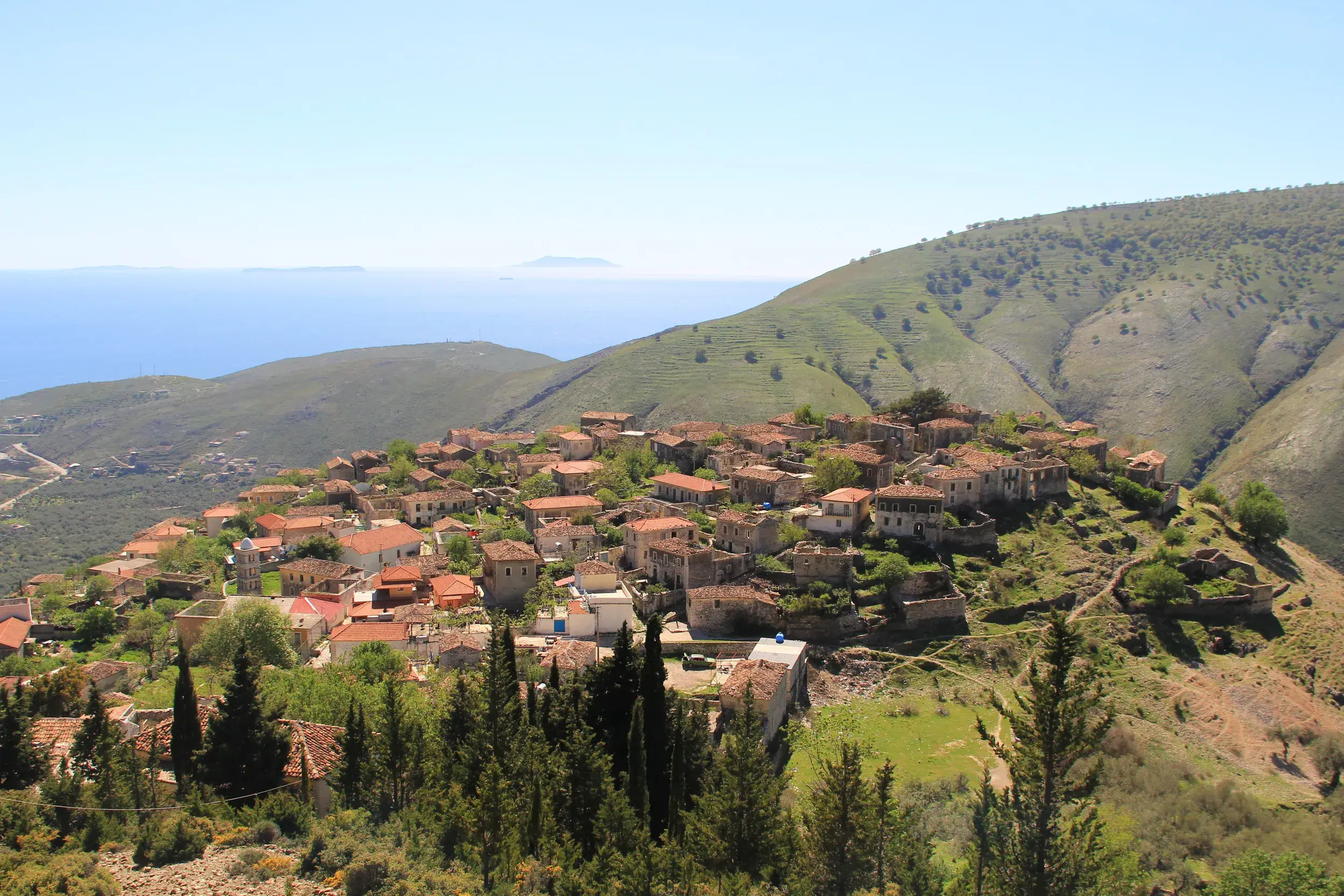 Aussicht bei einer Wanderung an der Albanischen Riviera auf das Bergdorf Qeparo und das tiefblaue Ionische Meer.