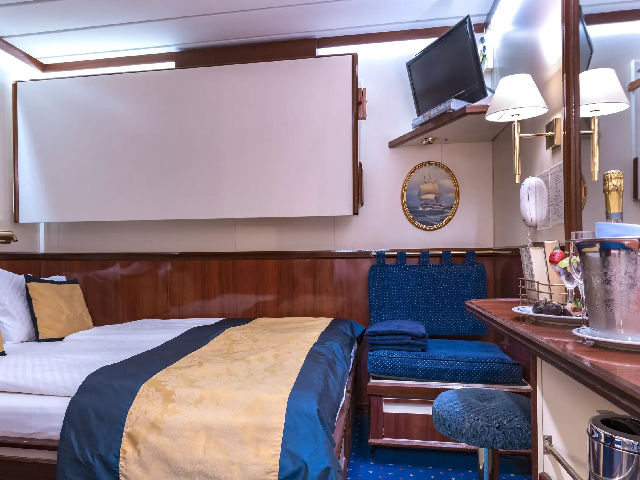 Elegante Doppelkabine der Kategorie 5 an Bord des Großseglers Star Flyer mit Doppelbett und maritimer Holzeinrichtung.