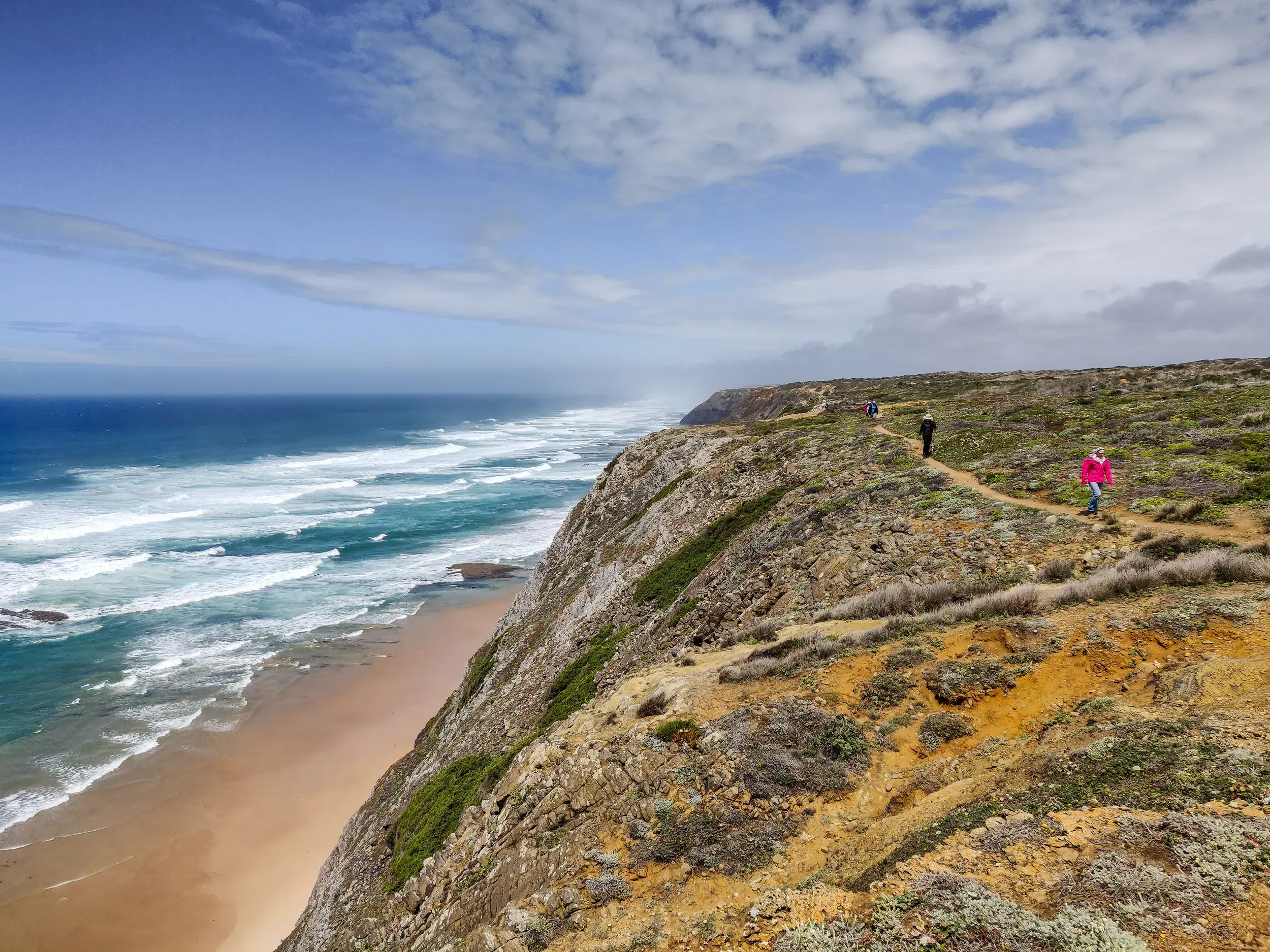 Wandergruppe auf dem Fischerpfad an der Steilküste der Algarve mit weitem Blick über den Atlantik und Sandstrände.
