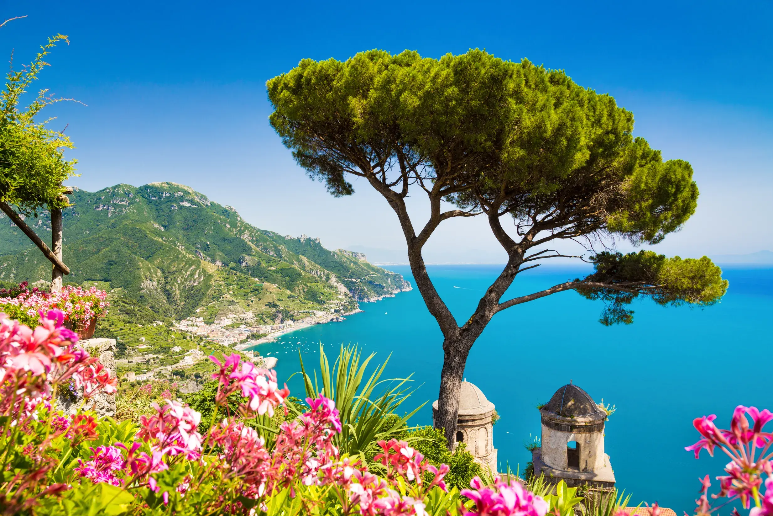 Pinie und Blumen im Garten der Villa Cimbrone in Ravello mit spektakulärem Blick auf die türkisblaue Amalfitana.
