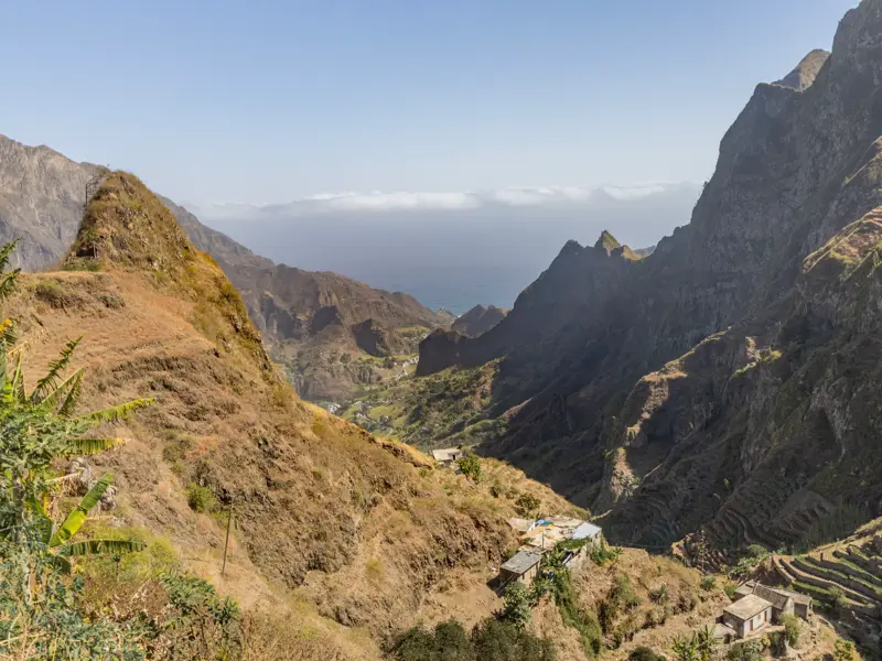 Panoramablick über ein tiefes, zerklüftetes Tal mit Terrassenfeldern und kleinen Dörfern auf der Wanderinsel Santo Antão.