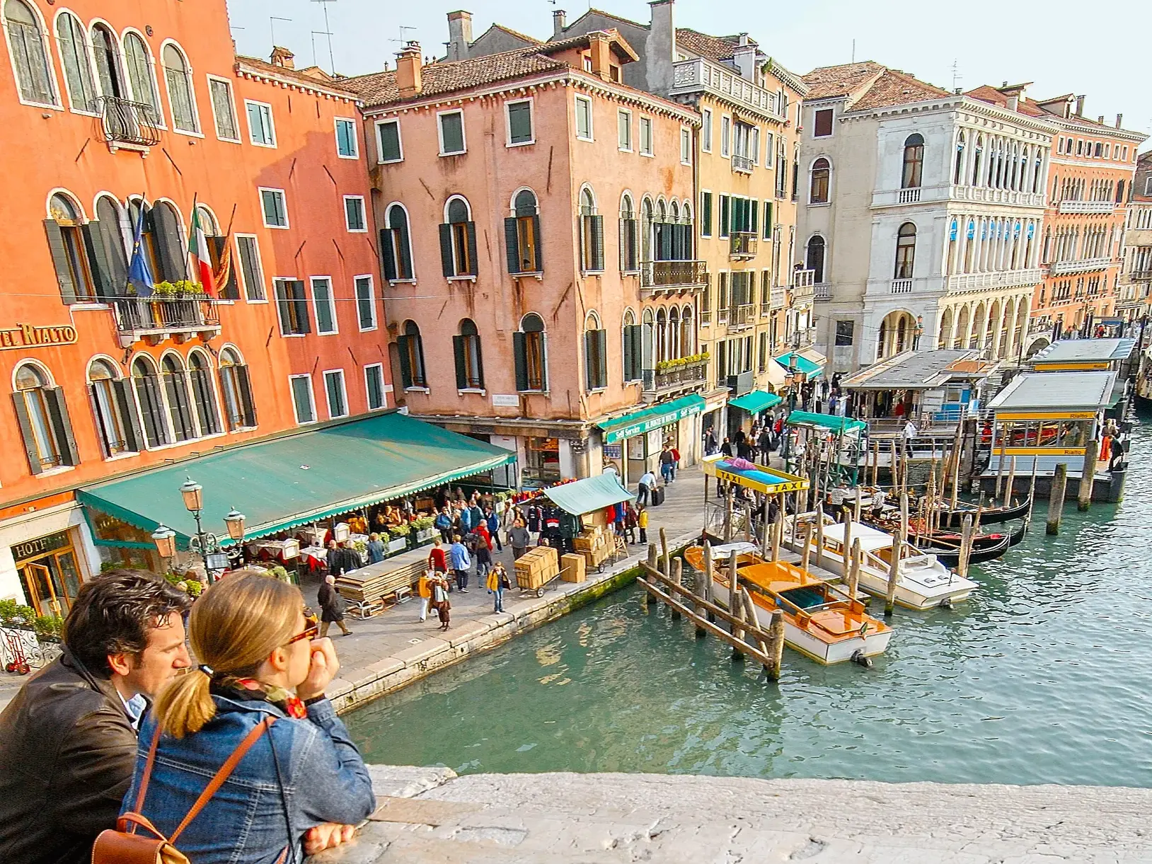 Blick von der Rialtobrücke auf bunte Palazzi, Boote und das bunte Treiben am Ufer in Venedig