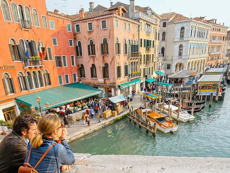 Blick von der Rialtobrücke auf bunte Palazzi, Boote und das bunte Treiben am Ufer in Venedig