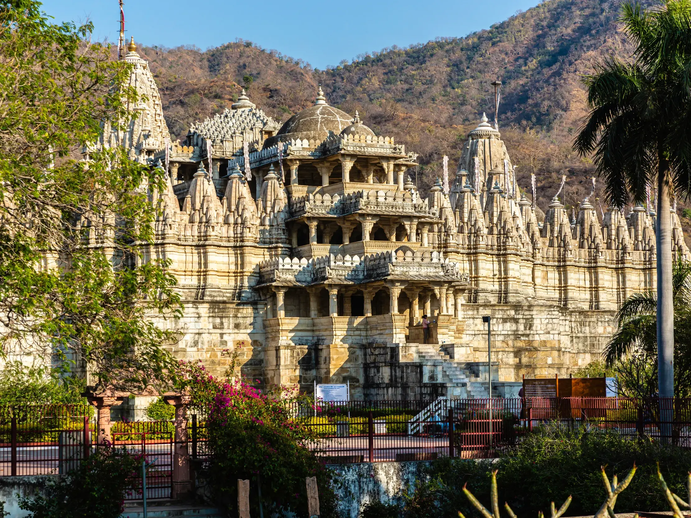 Der beeindruckende Jain-Tempel in Ranakpur aus weißem Marmor vor der Hügellandschaft der Aravalli-Berge in Rajasthan.