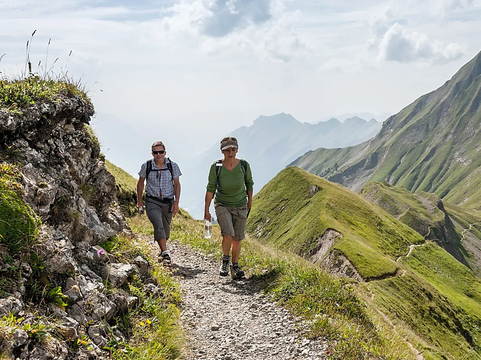 Zwei Teilnehmerinnen einer Studiosus Wanderreise auf einem schmalen Bergpfad in der beeindruckenden Gebirgslandschaft des Kaukasus.