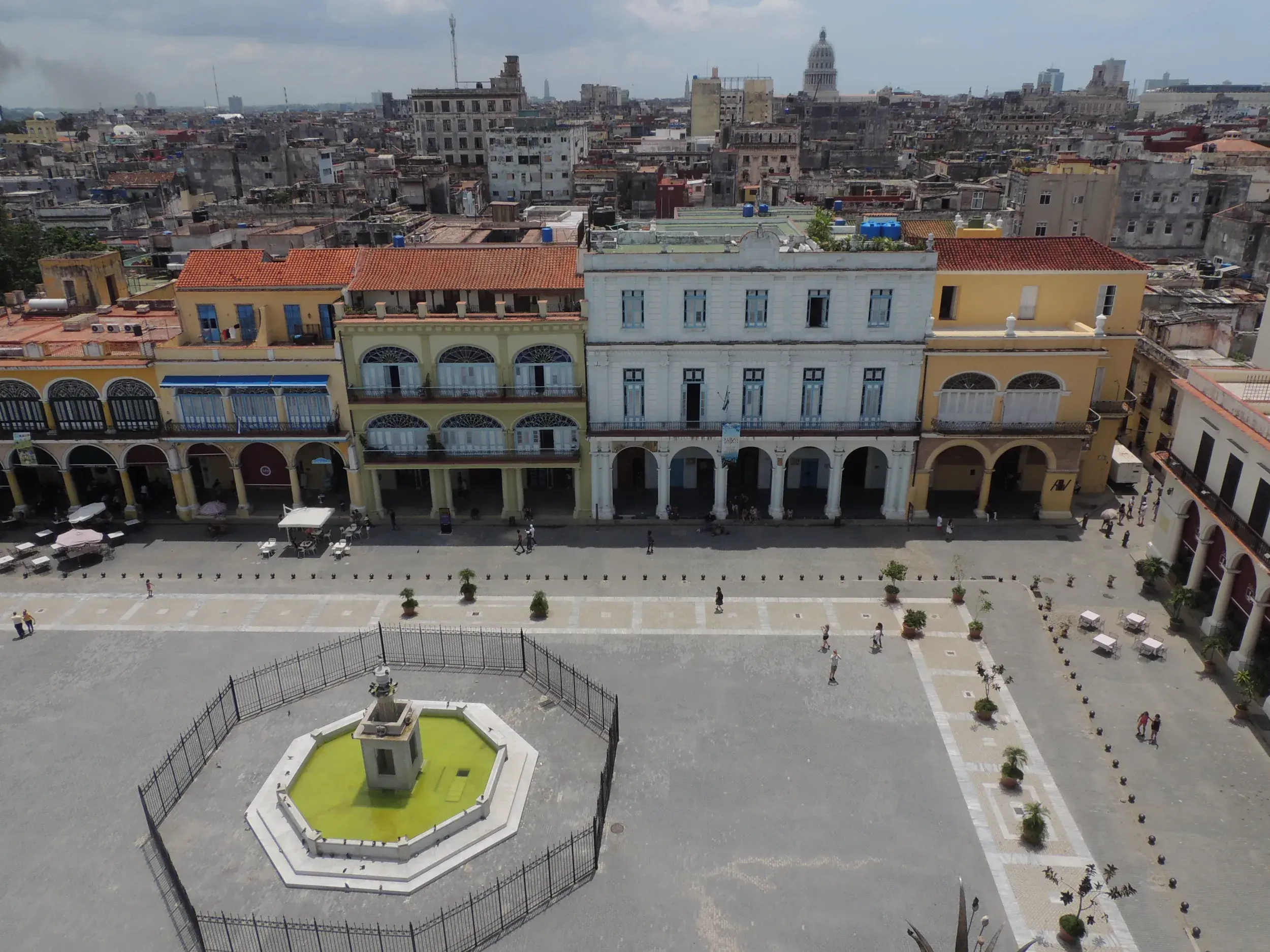 Blick von oben auf die historische Plaza Vieja in Havanna, umgeben von farbenfrohen Kolonialbauten des UNESCO-Weltkulturerbes.