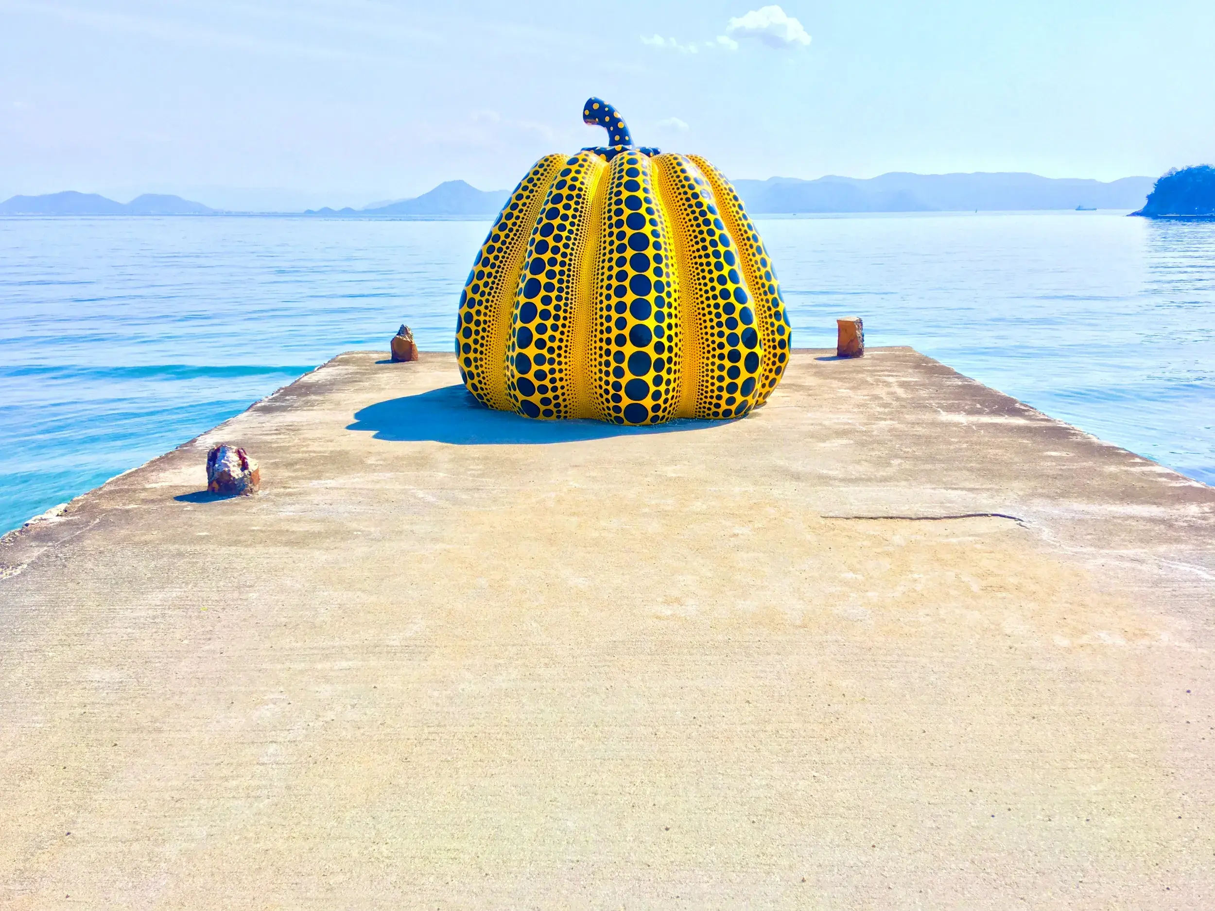 Yayoi Kusamas gelbe Kürbis-Skulptur auf einem Pier der Kunstinsel Naoshima während einer Studienreise in Japan.