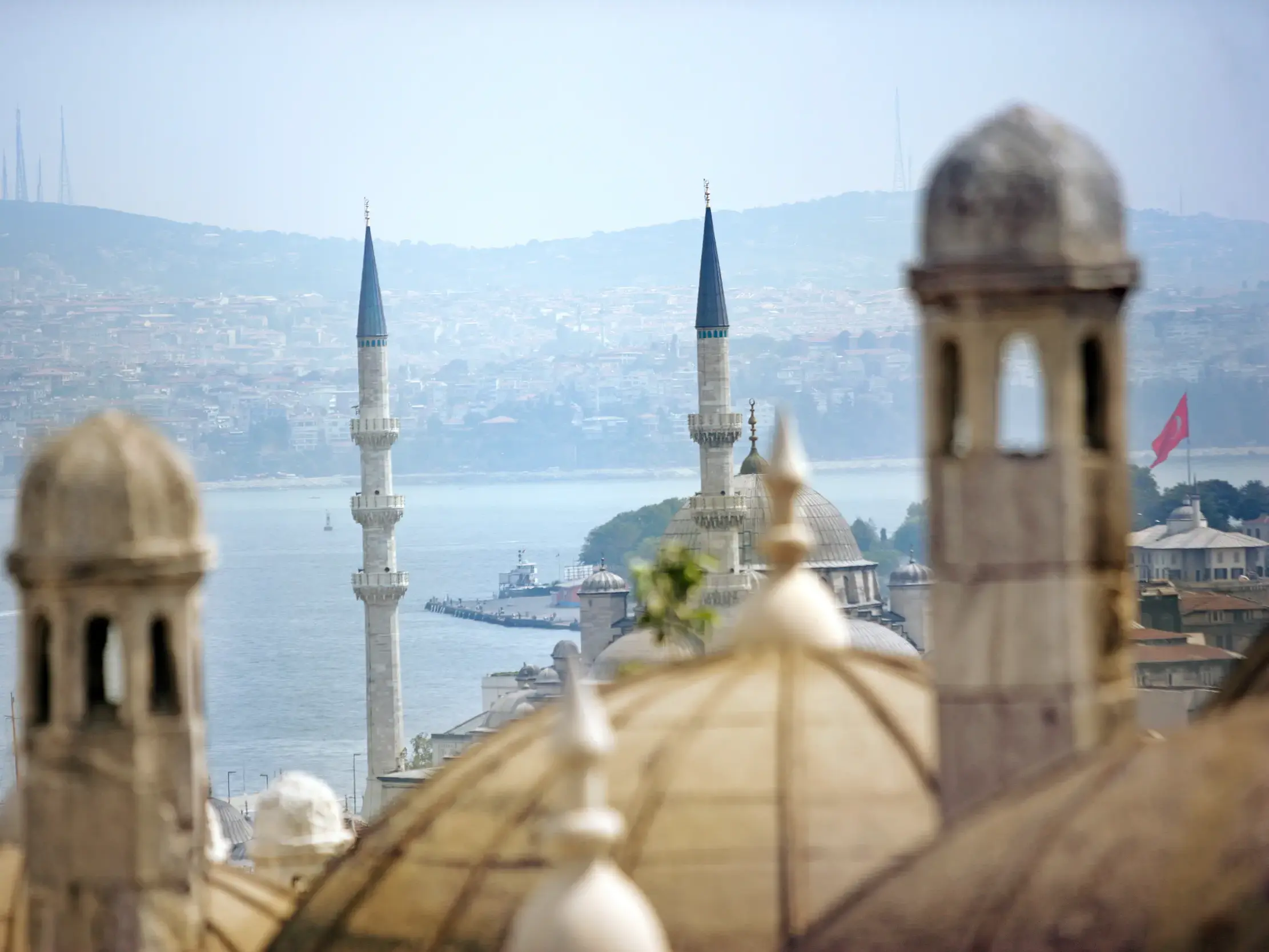 Ikonischer Blick über die Kuppeln und Minarette einer Moschee auf den Bosporus und die Skyline von Istanbul in der Türkei.