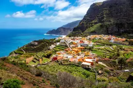 Malerisches Dorf Agulo auf La Gomera mit bunten Häusern, umgeben von grünen Terrassenfeldern an der Steilküste des Atlantiks.