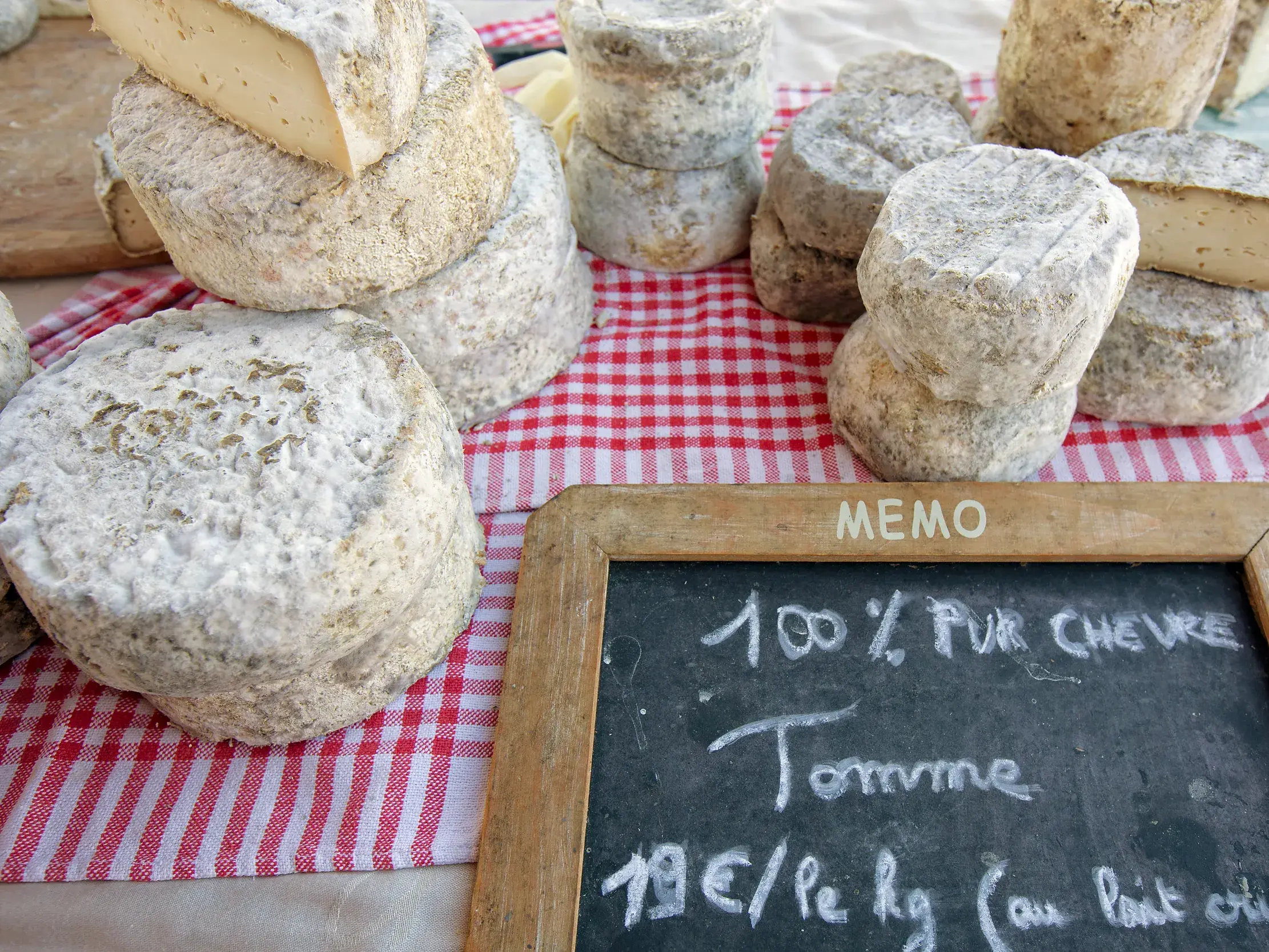 Rustikale Laibe von Tomme-Ziegenkäse auf dem Markt von Sarlat, eine kulinarische Spezialität aus dem Périgord.