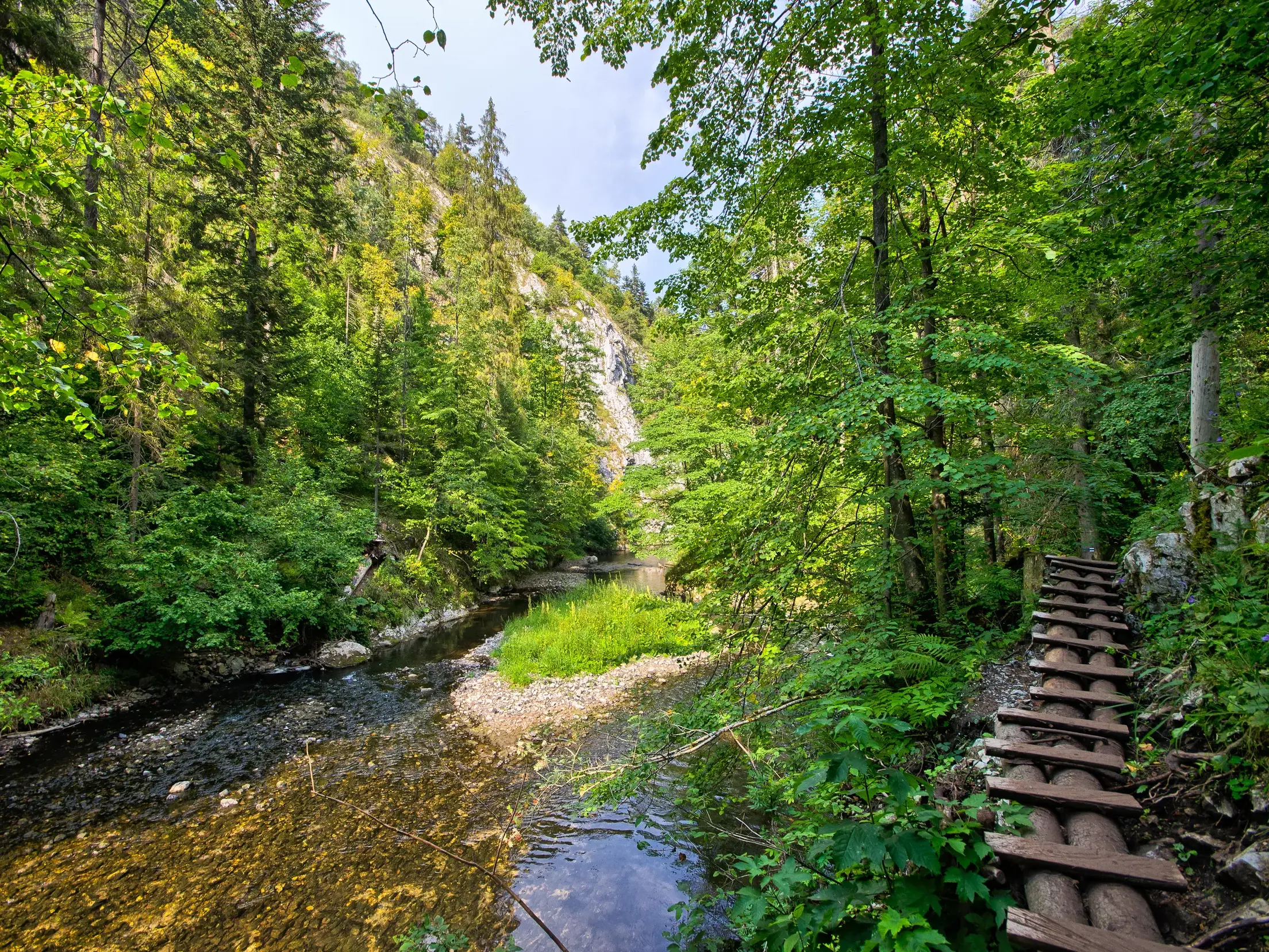 Abenteuerlicher Wanderweg mit Holzstegen führt an einem steilen Hang entlang des Flusses im Canyon Hornad Durchbruch.