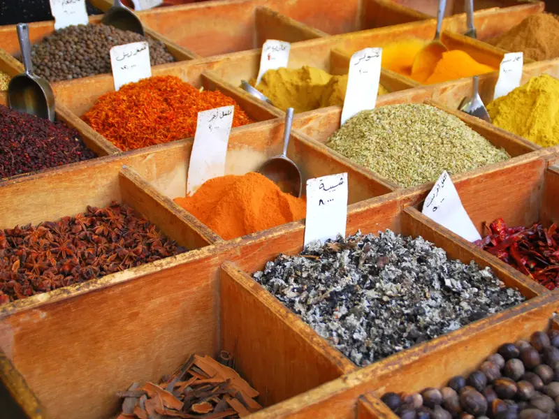Bunte Gewürze und Kräuter in Holzkisten auf dem historischen Souk Al-Musawkaf in Unaizah, Saudi-Arabien.