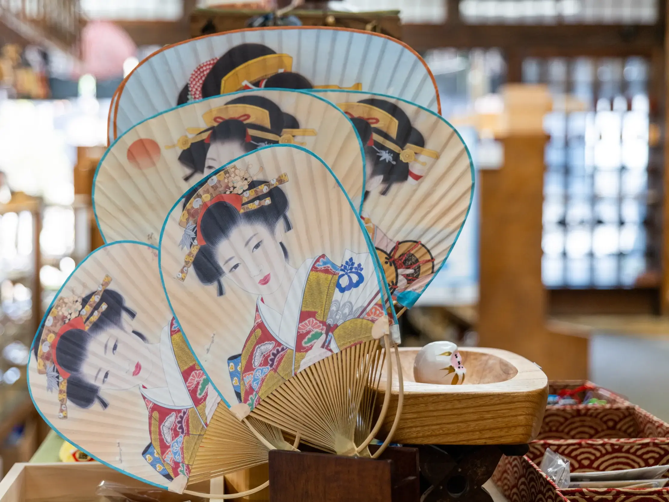 Traditionelle japanische Fächer, verziert mit Geisha-Motiven, liegen in einem Souvenirgeschäft in Kyoto zum Verkauf.