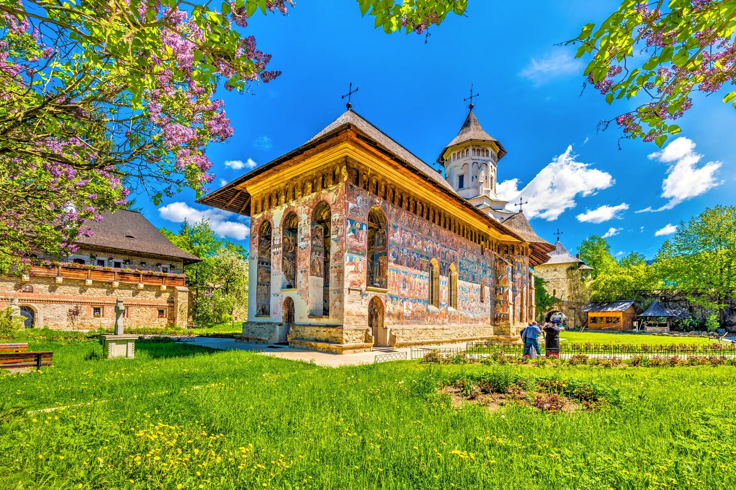 Farbenprächtige Außenfresken des UNESCO-Welterbes Kloster Voronet in der rumänischen Region Südbukowina unter blauem Himmel.