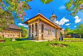 Farbenprächtige Außenfresken des UNESCO-Welterbes Kloster Voronet in der rumänischen Region Südbukowina unter blauem Himmel.
