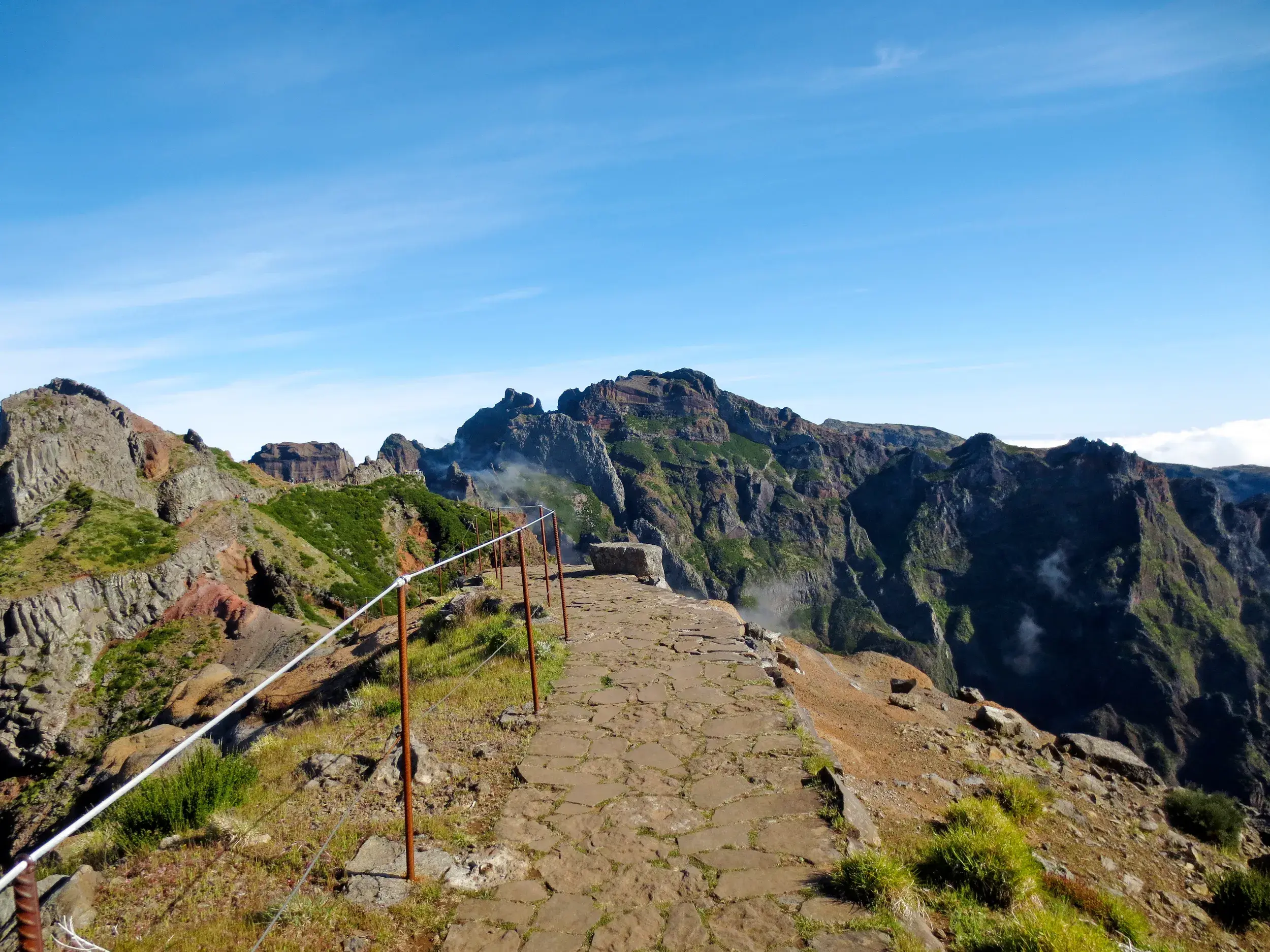 Gepflasterter Wanderweg mit Seilgeländer auf der Gratwanderung zum Pico Ruivo, dem höchsten Berg auf Madeira.
