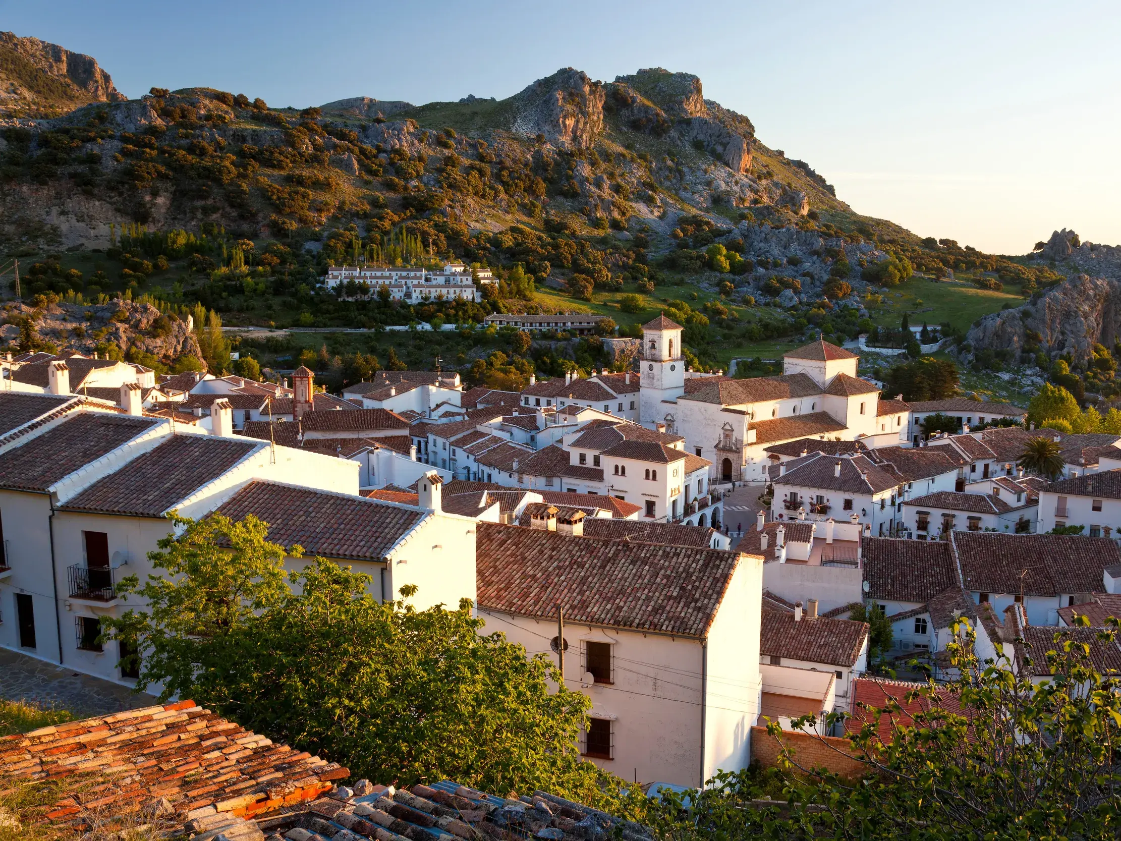 Das weiße Bergdorf Grazalema in Andalusien, eingebettet in die grüne Berglandschaft des Naturparks Sierra de Grazalema.